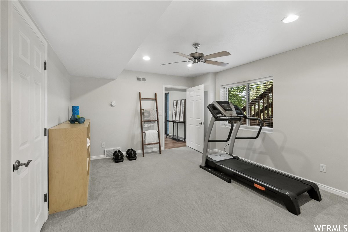 Exercise area with light carpet and ceiling fan