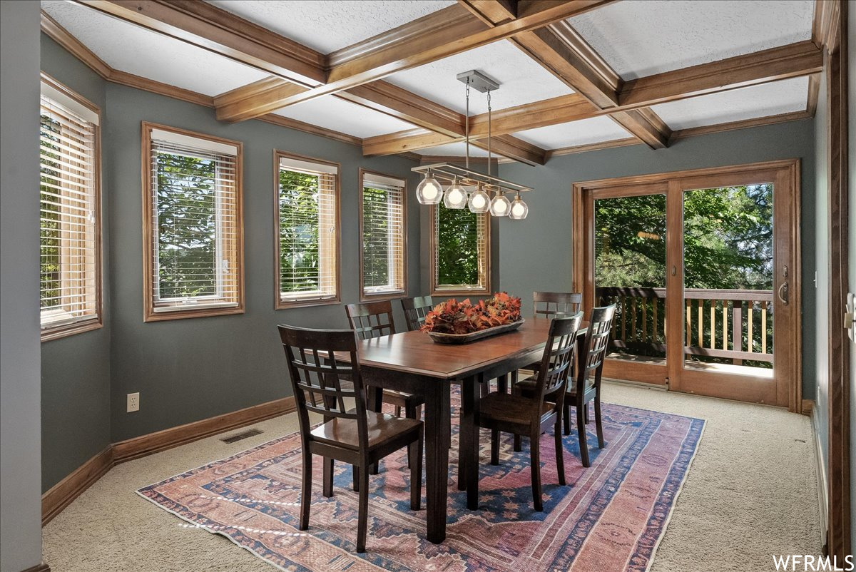 Carpeted dining room with beamed ceiling and coffered ceiling