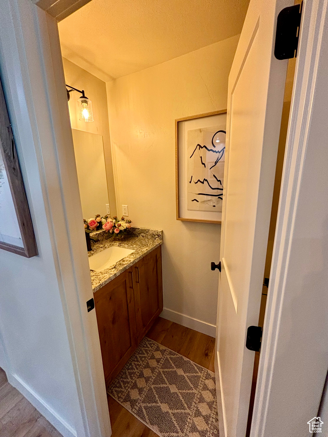 Bathroom featuring a textured ceiling, wood-type flooring, and vanity