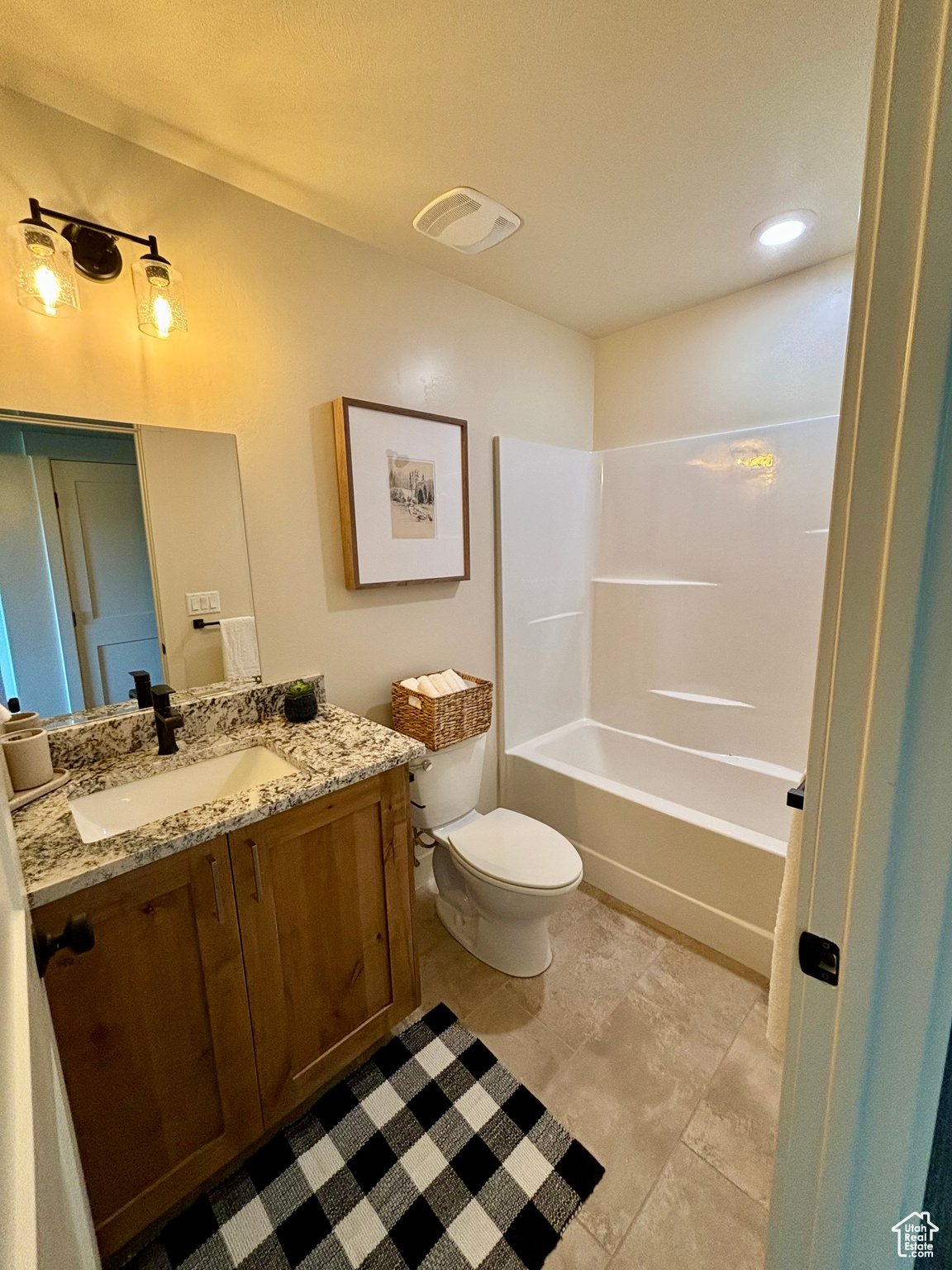 Full bathroom with tile patterned floors, shower / washtub combination, vanity, and toilet