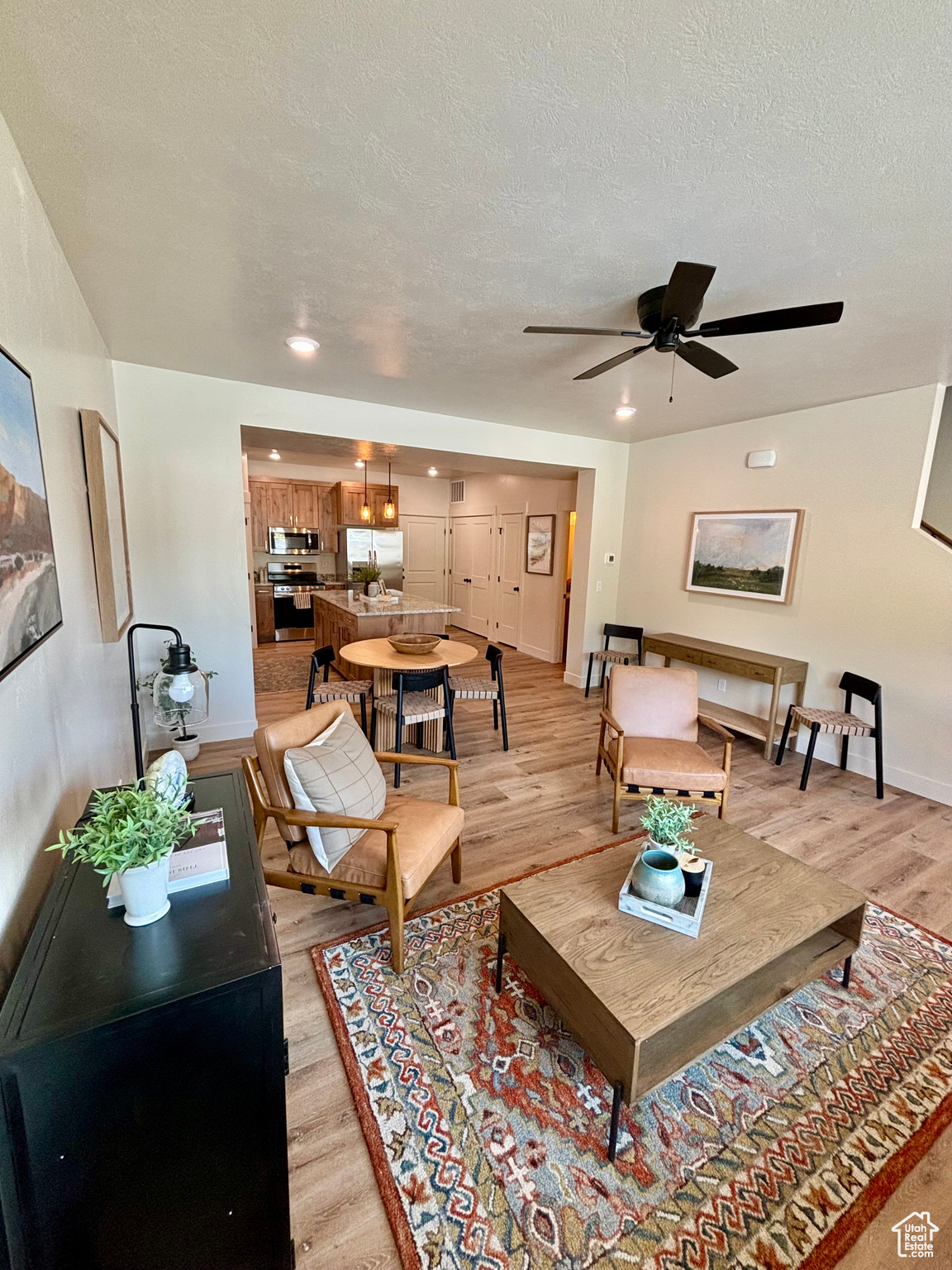 Living room featuring light hardwood / wood-style floors, ceiling fan, and a textured ceiling