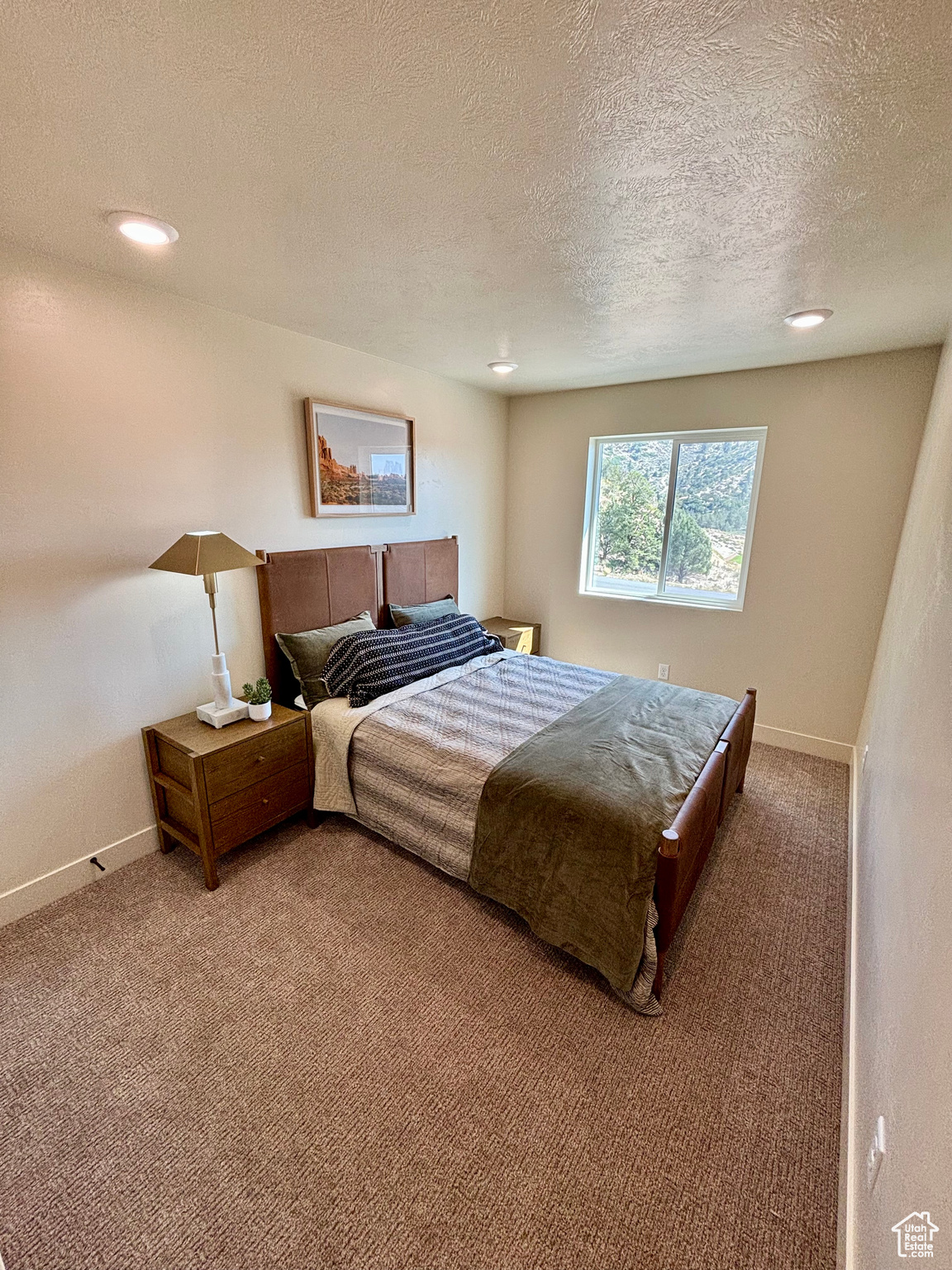 Bedroom with a textured ceiling and carpet floors