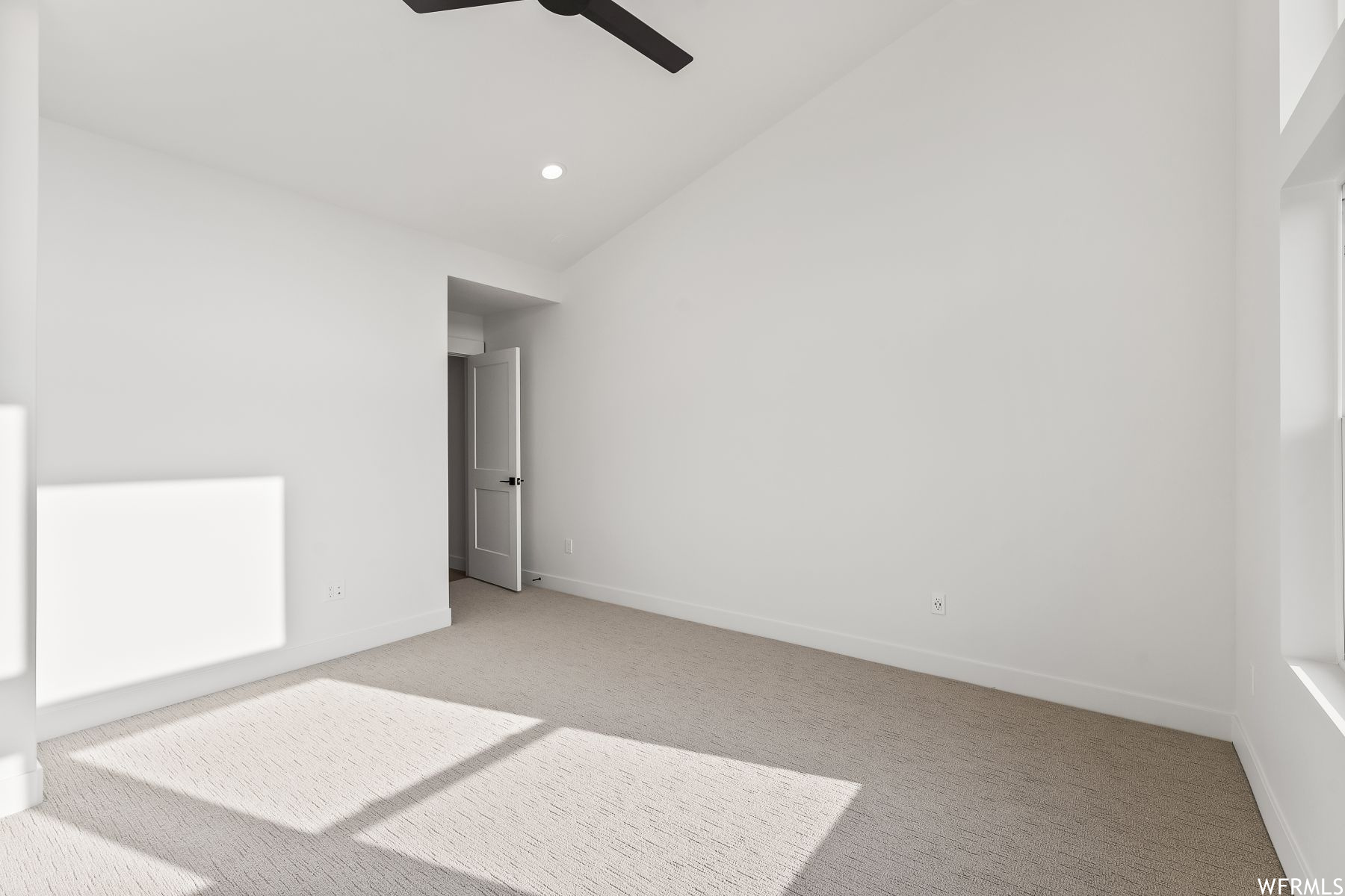 Mater bedroom featuring lofted ceiling, ceiling fan, and light colored carpet