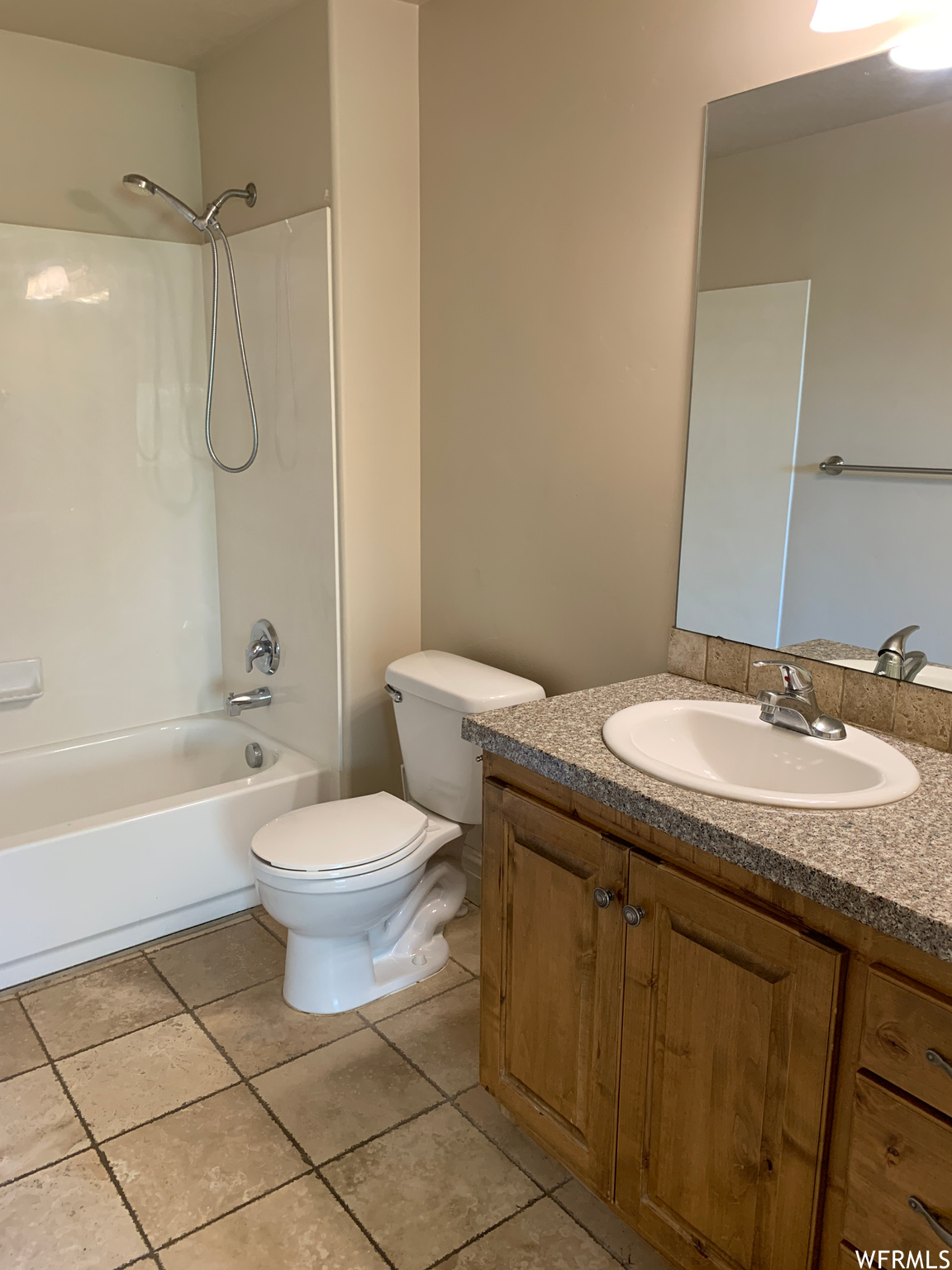 Full bathroom featuring oversized vanity,  shower combination, mirror, and light tile floors