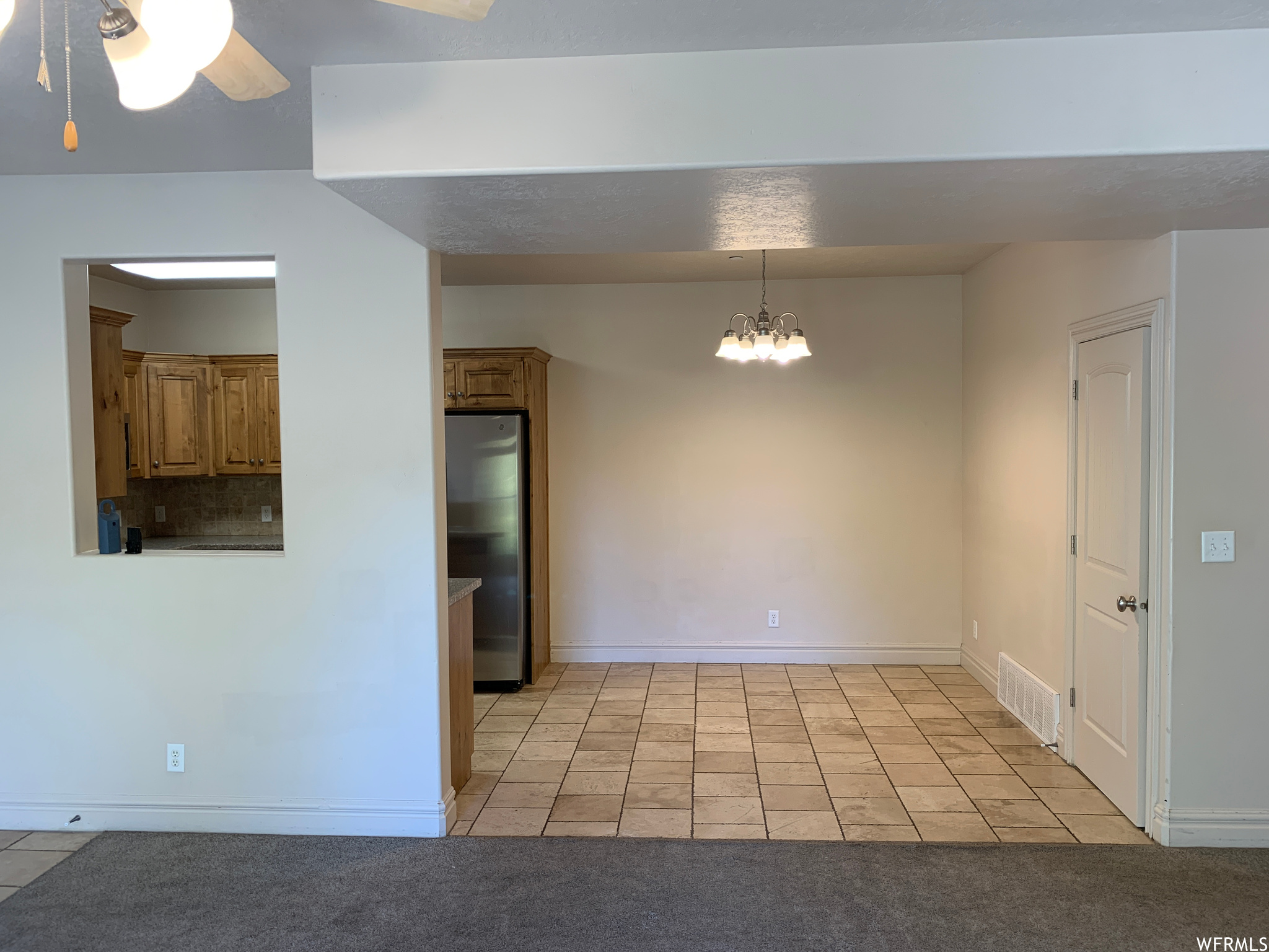 Kitchen with light carpet, backsplash, stainless steel refrigerator, and ceiling fan