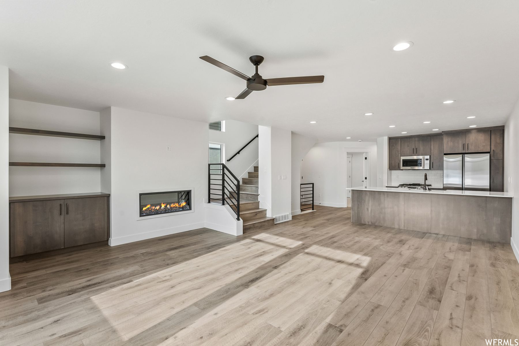 Great room featuring light hardwood / wood-style flooring and ceiling fan