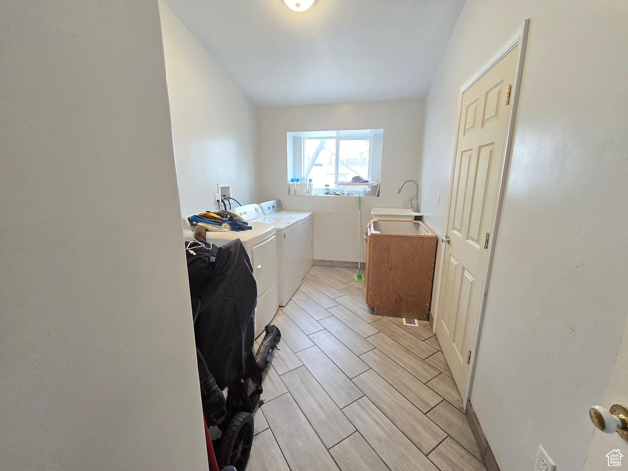 Washroom featuring hookup for a washing machine, light hardwood / wood-style flooring, separate washer and dryer, and sink