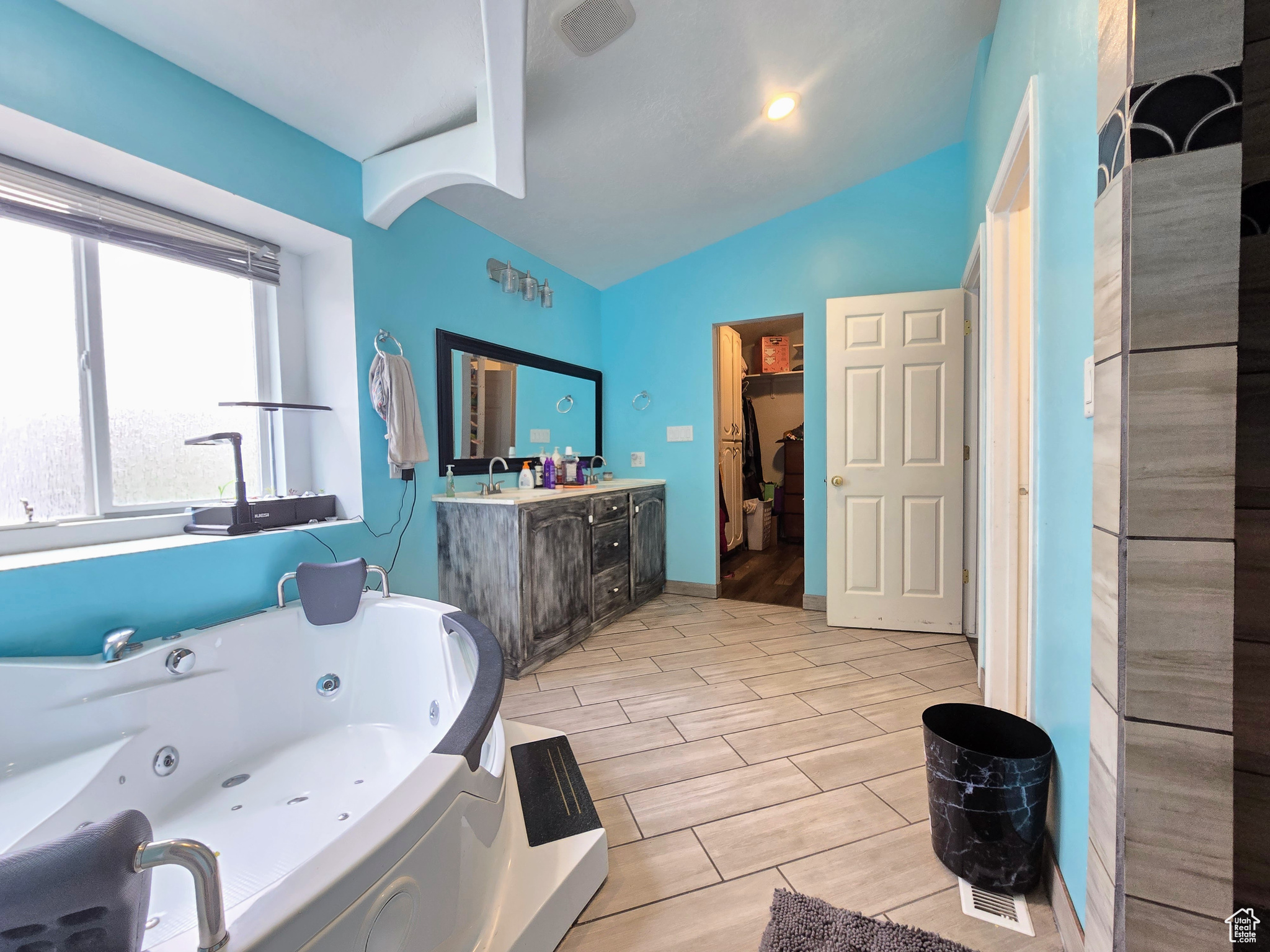 Bathroom with tile flooring, vaulted ceiling, and vanity