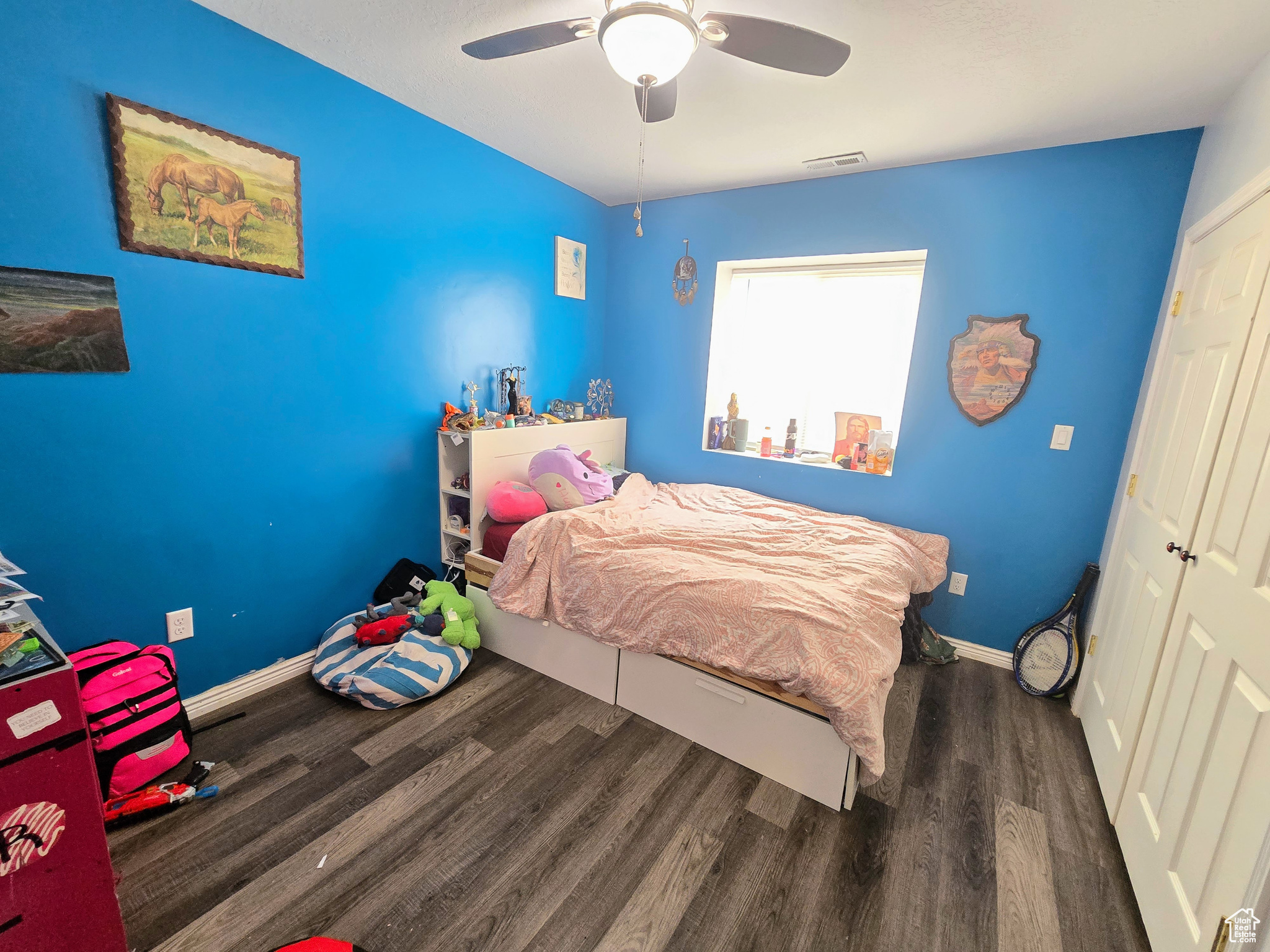 Bedroom featuring a closet, ceiling fan, and dark wood-type flooring