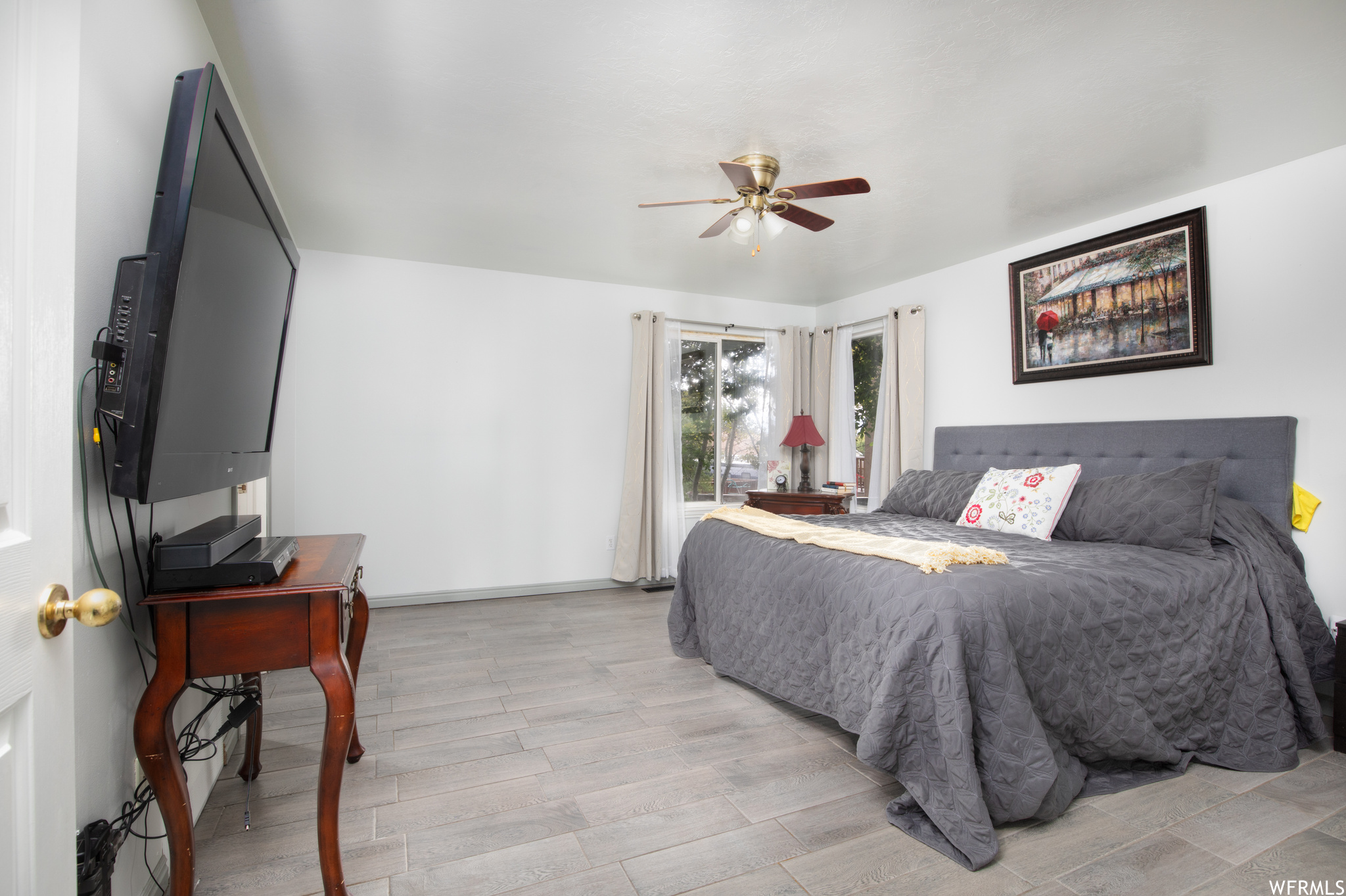 Main bedroom with light tiled floors and ceiling fan.