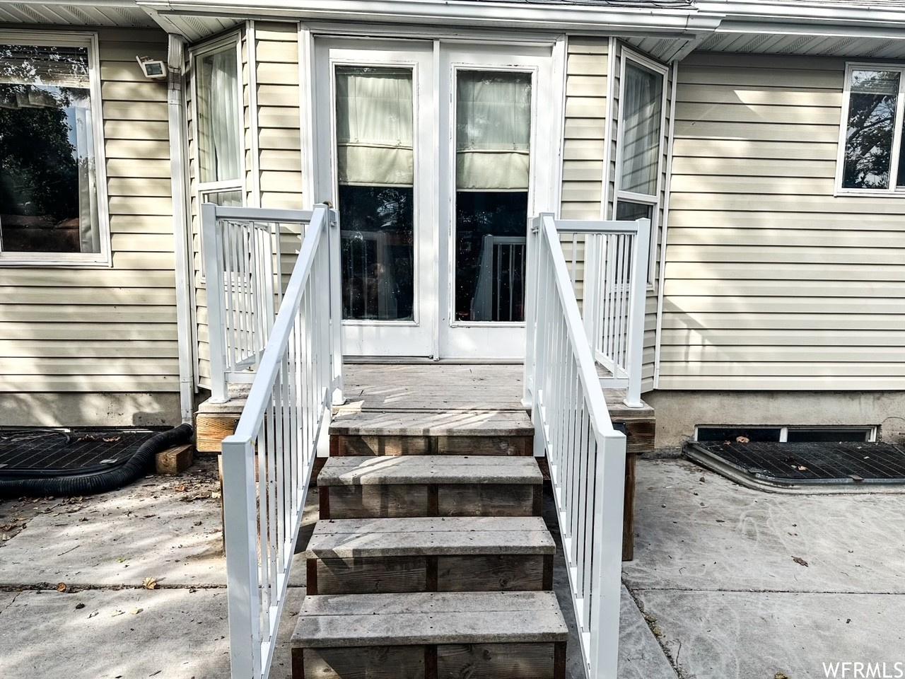 Property entrance with a deck with new aluminum handrails