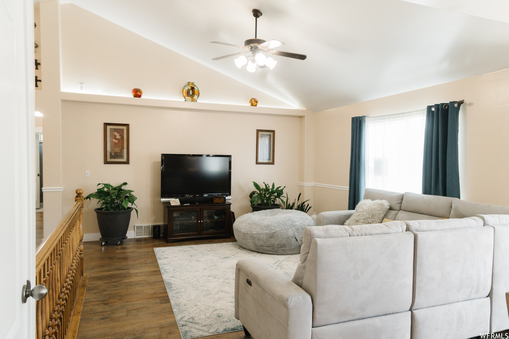 Living room featuring vaulted ceiling, light hardwood floors, and ceiling fan