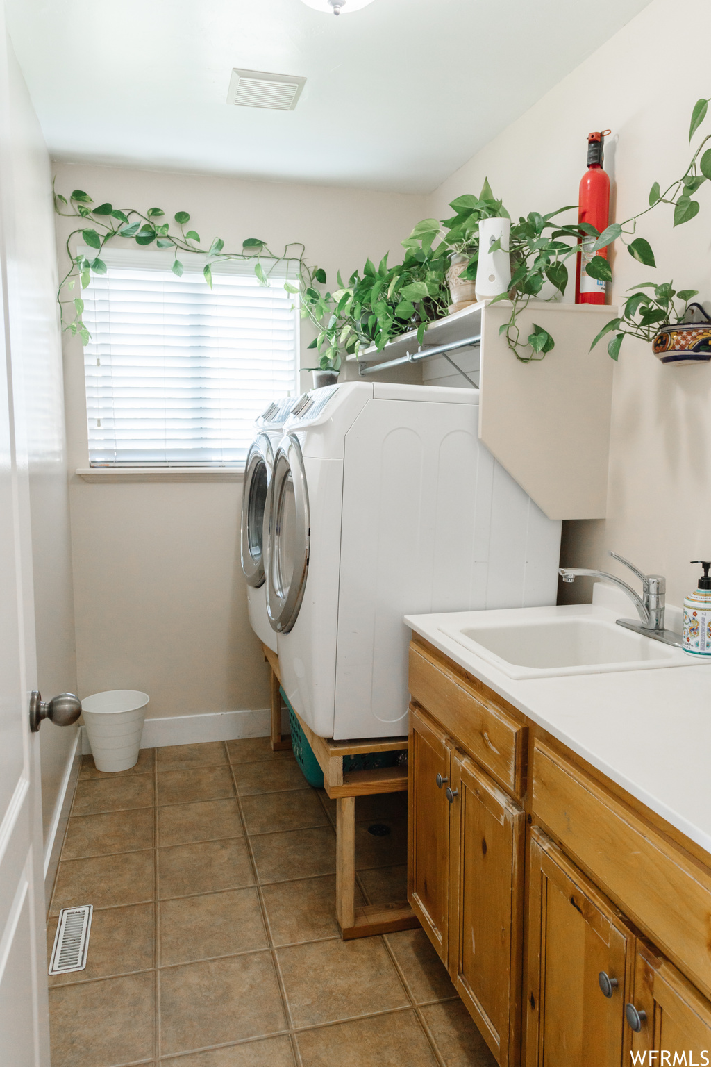 Laundry room featuring washing machine and clothes dryer and light tile floors