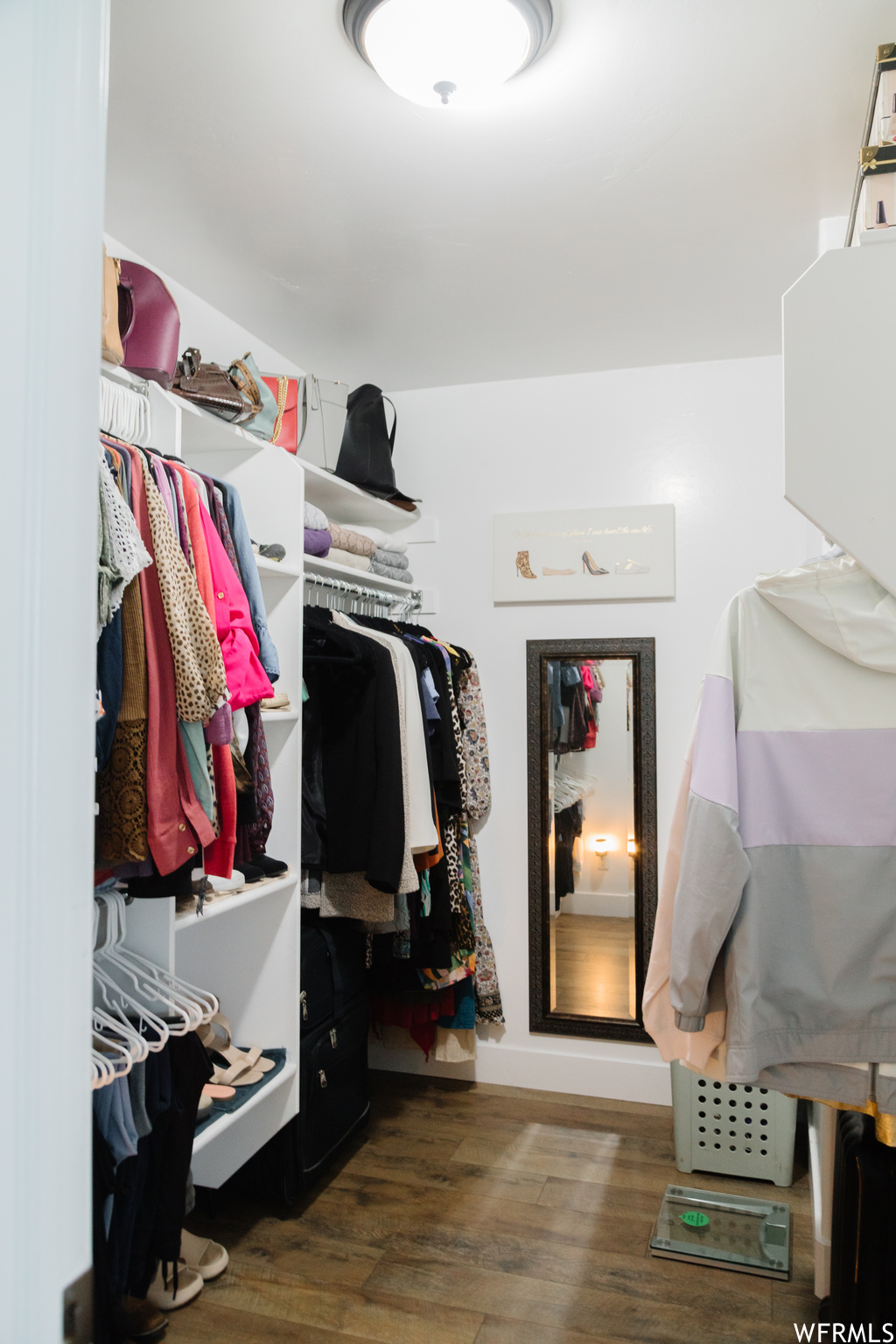 Walk in closet featuring hardwood flooring