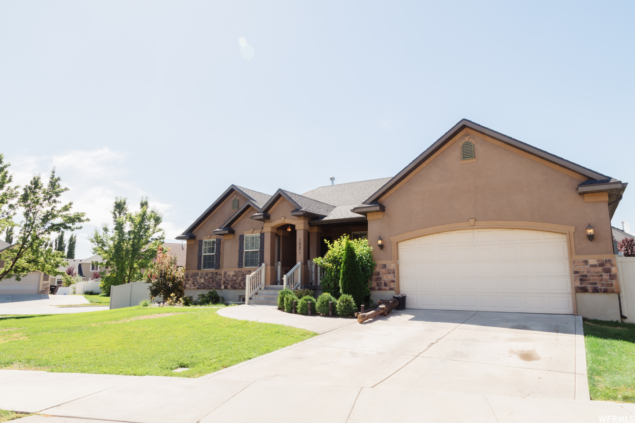 Ranch-style house featuring garage and a front lawn