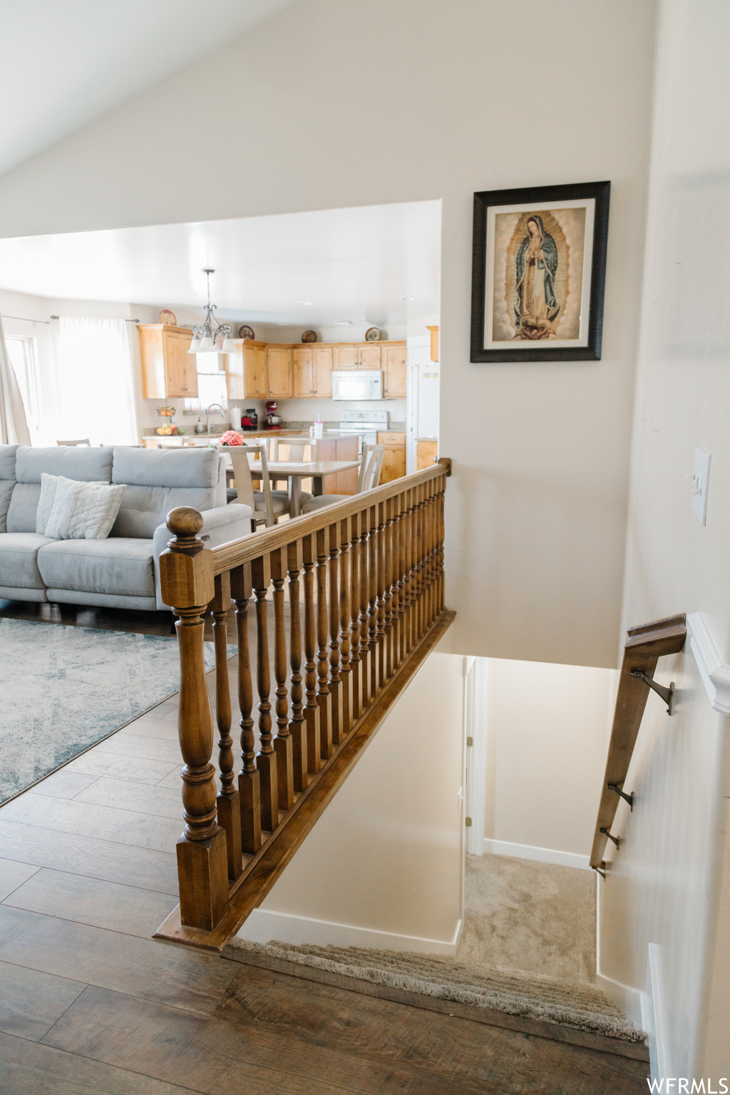 Stairway with light carpet and vaulted ceiling