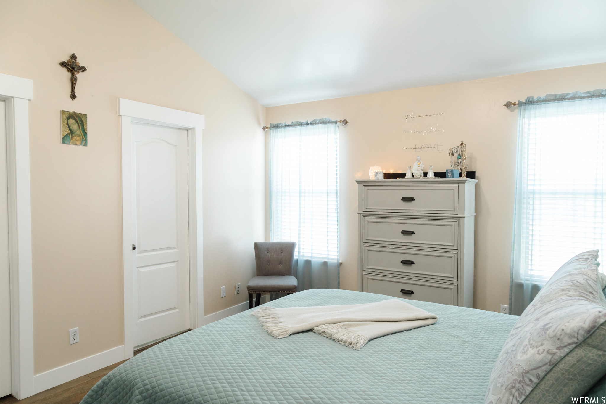 Bedroom featuring multiple windows and vaulted ceiling