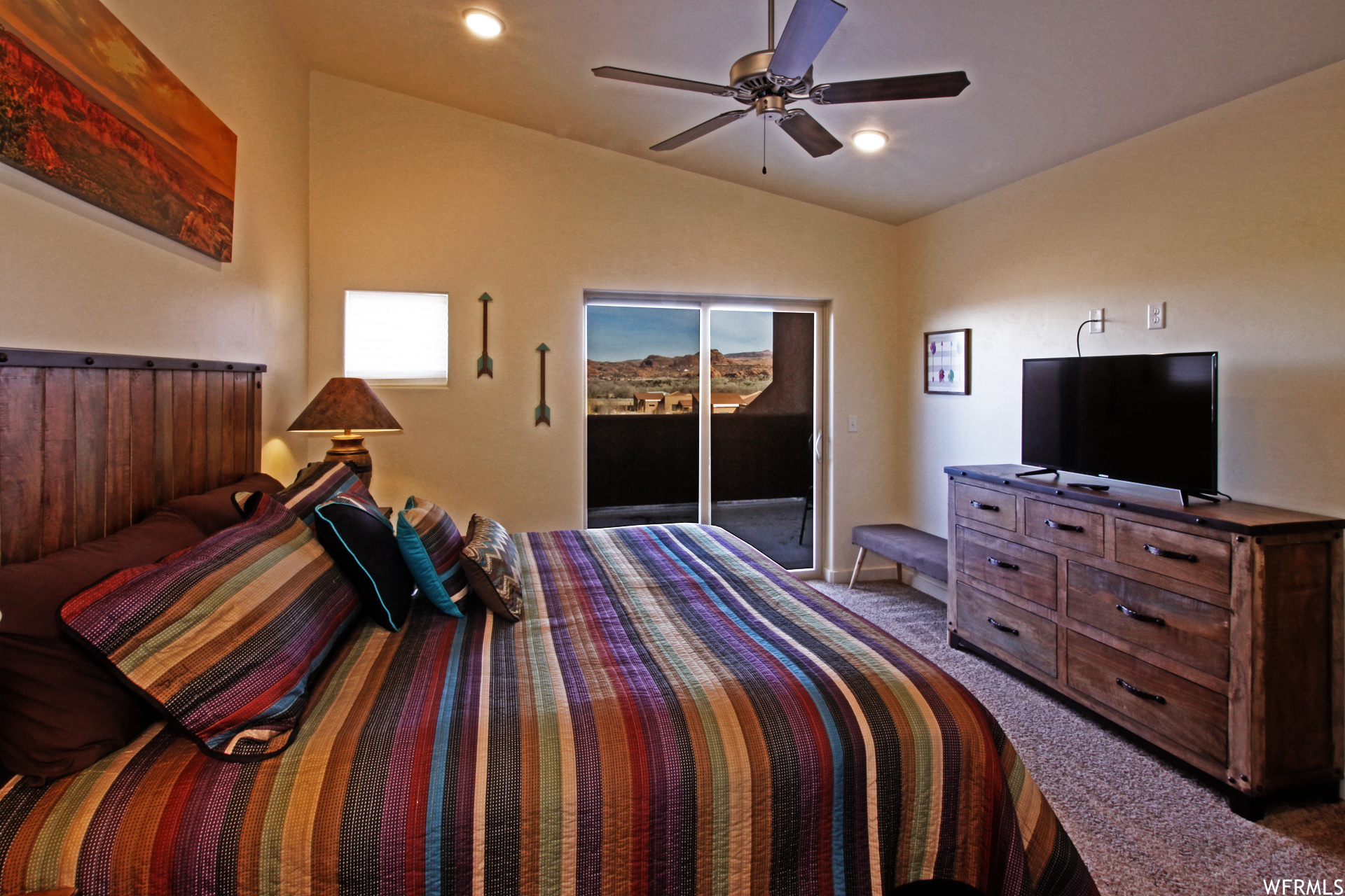 Carpeted bedroom with lofted ceiling and ceiling fan