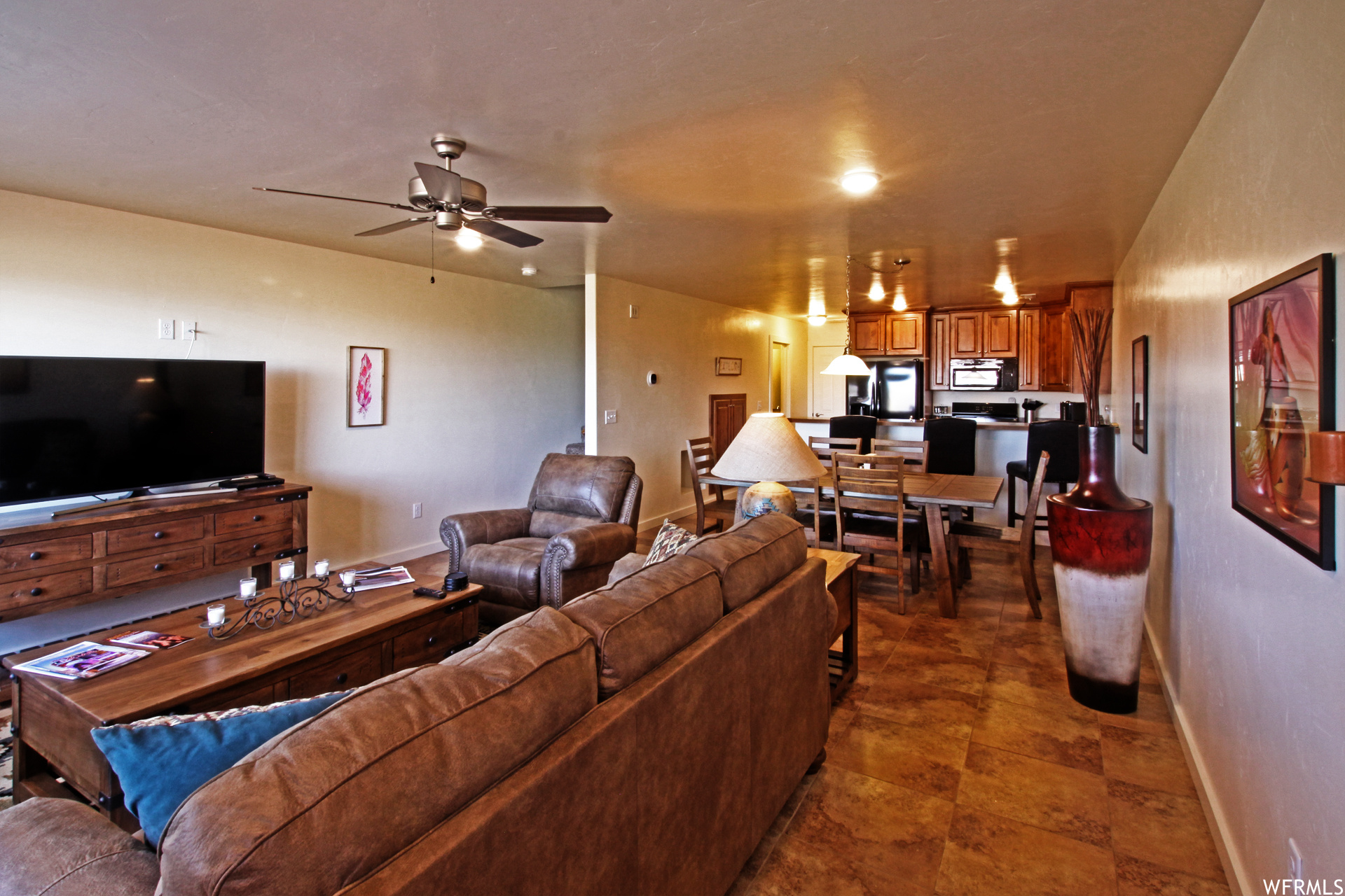 Living room featuring dark tile flooring and ceiling fan