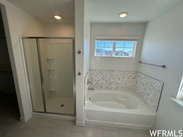 Master bath with shower and tub with tile surround.