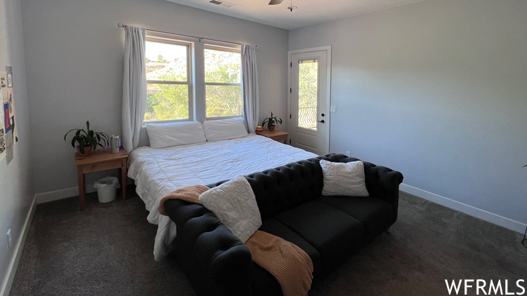 Bedroom featuring access to exterior, dark colored carpet, and ceiling fan