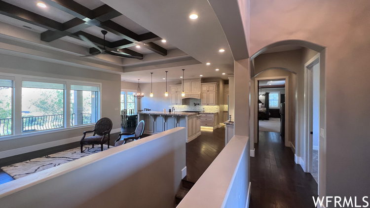 Interior space featuring coffered ceiling, dark hardwood floors, and beam ceiling