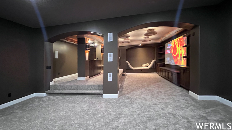 Home theater featuring a raised ceiling and carpet
