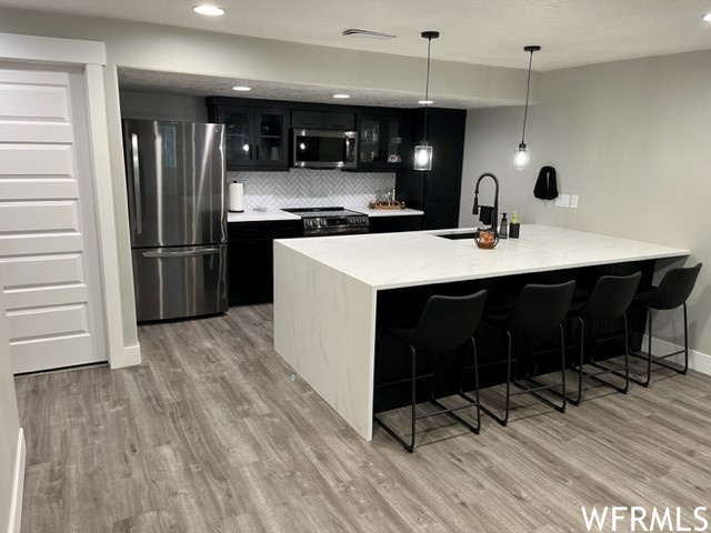 Full kitchen with oversized waterfall island and access to utility closet on left.