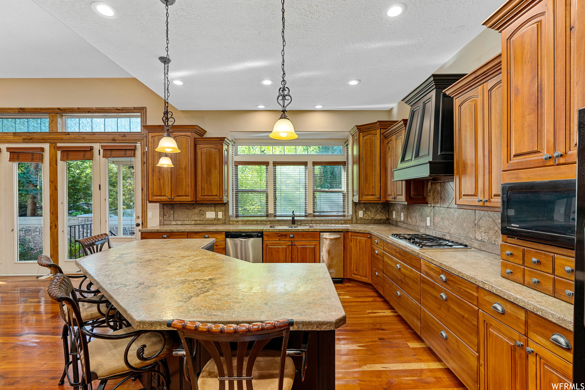 Kitchen with a kitchen island, a healthy amount of sunlight, and premium range hood