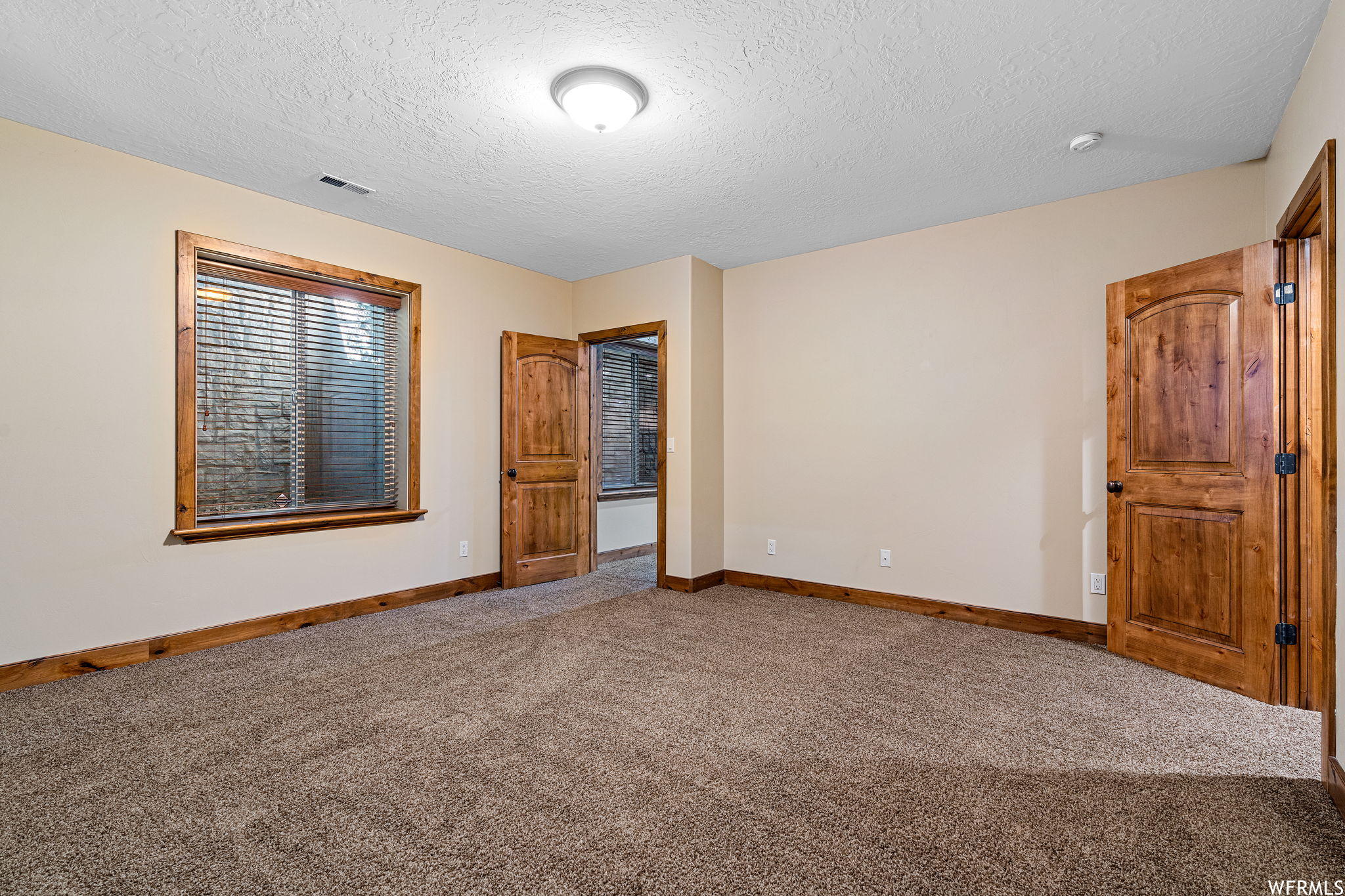 Empty room featuring carpet floors and a textured ceiling
