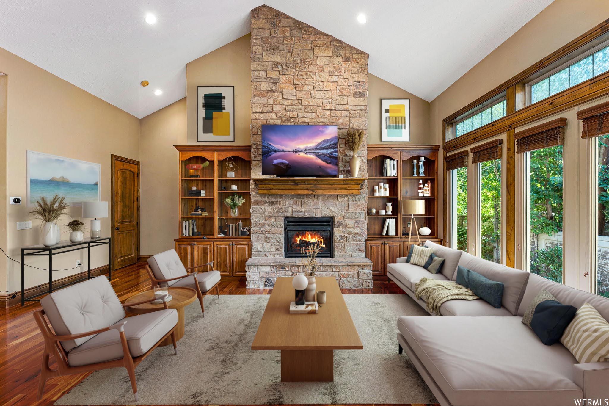Furnished Living room with vaulted ceiling high, light hardwood floors, and a fireplace