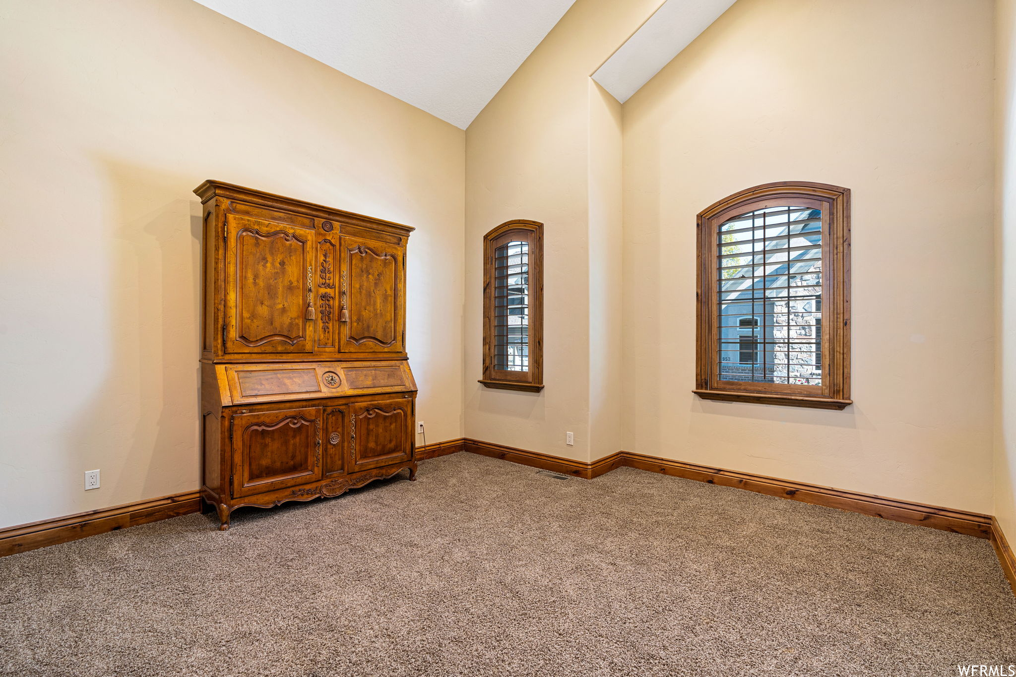 Spare room with light carpet and vaulted ceiling high