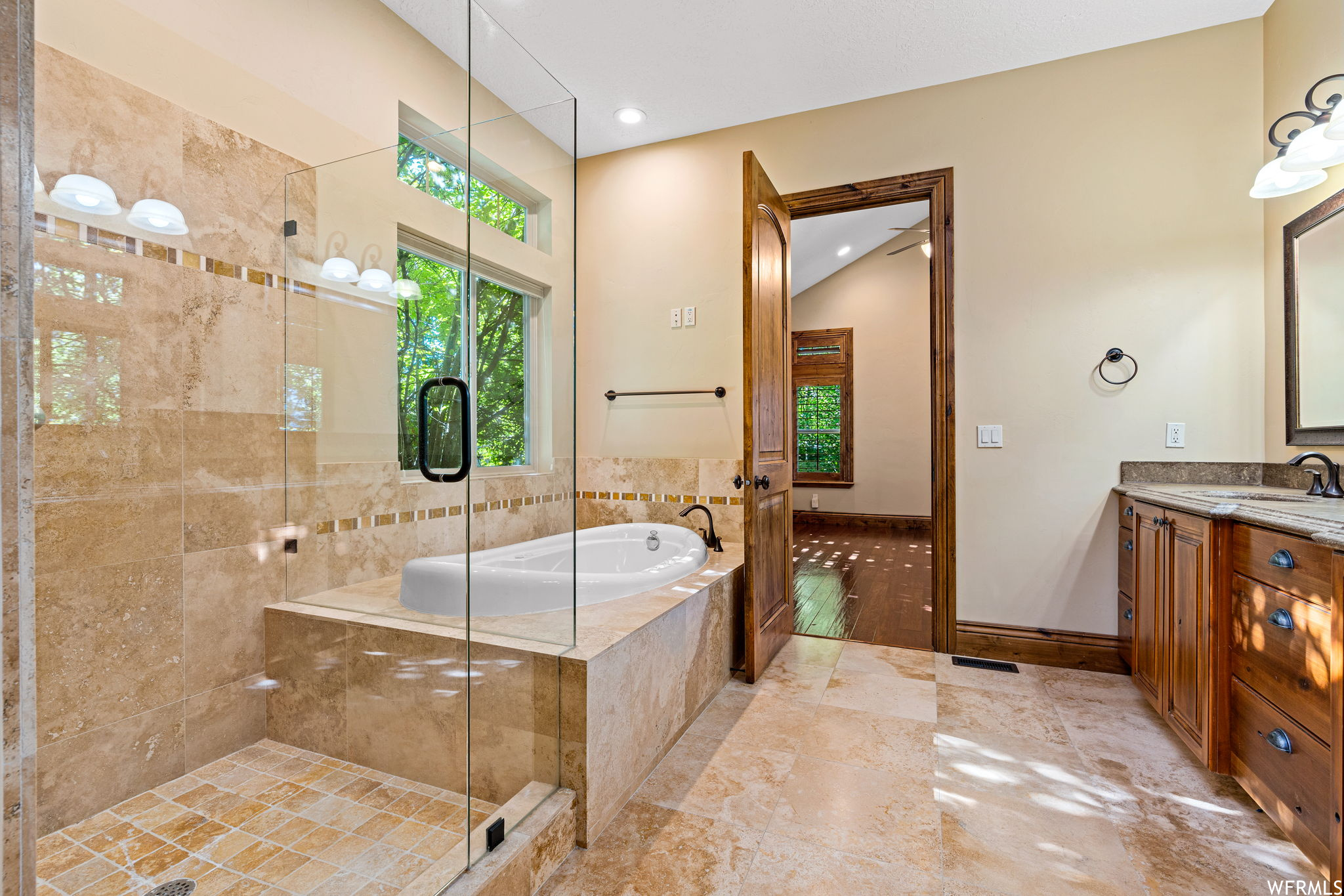Bathroom featuring separate shower and tub, vanity, and tile floors