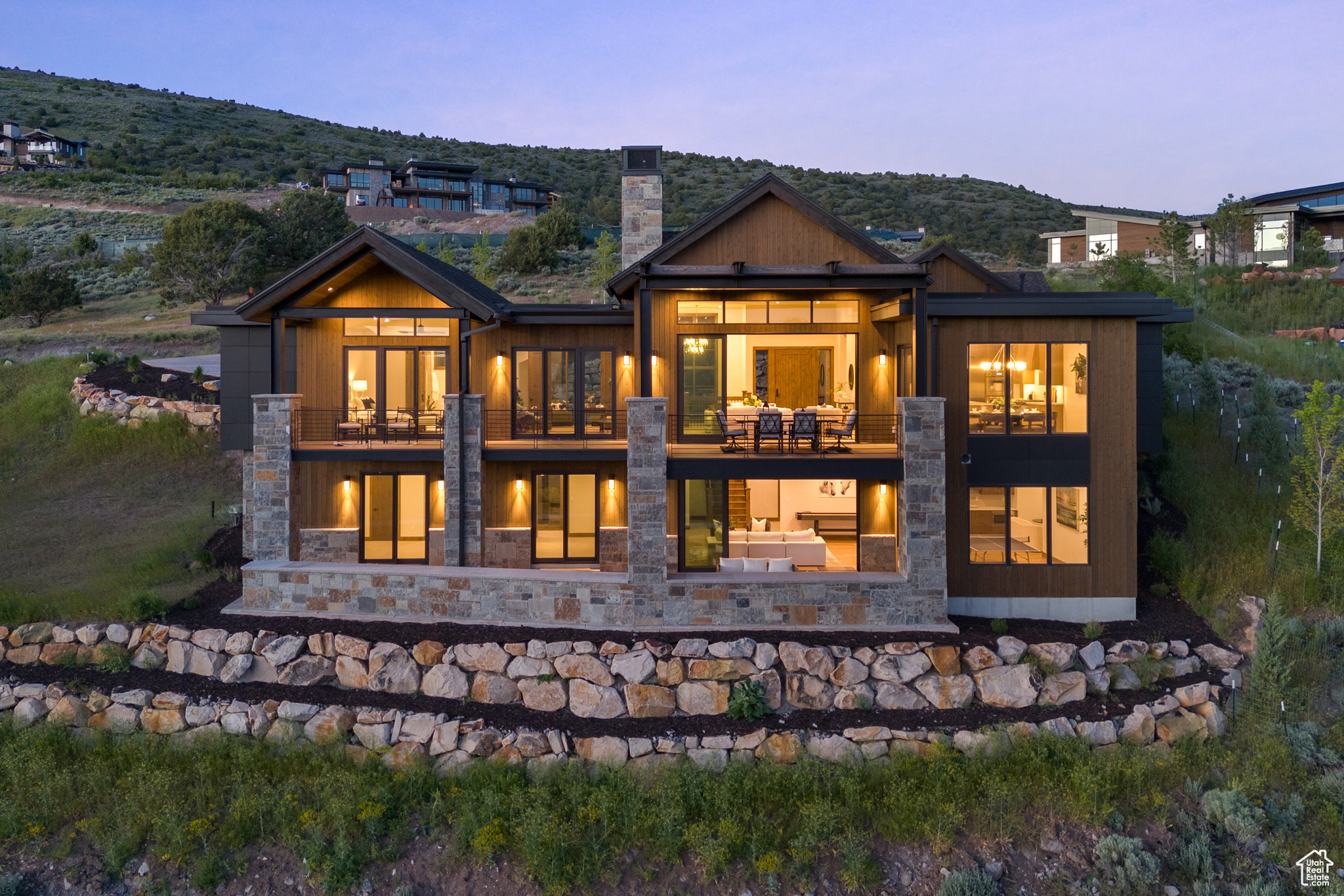 Back house at dusk featuring a balcony and a mountain view