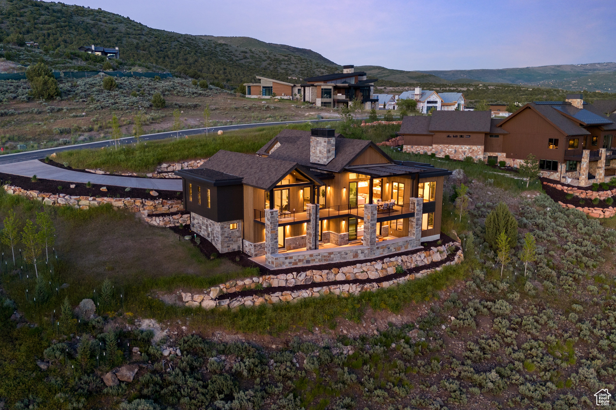 Back house at dusk featuring a mountain view and a balcony