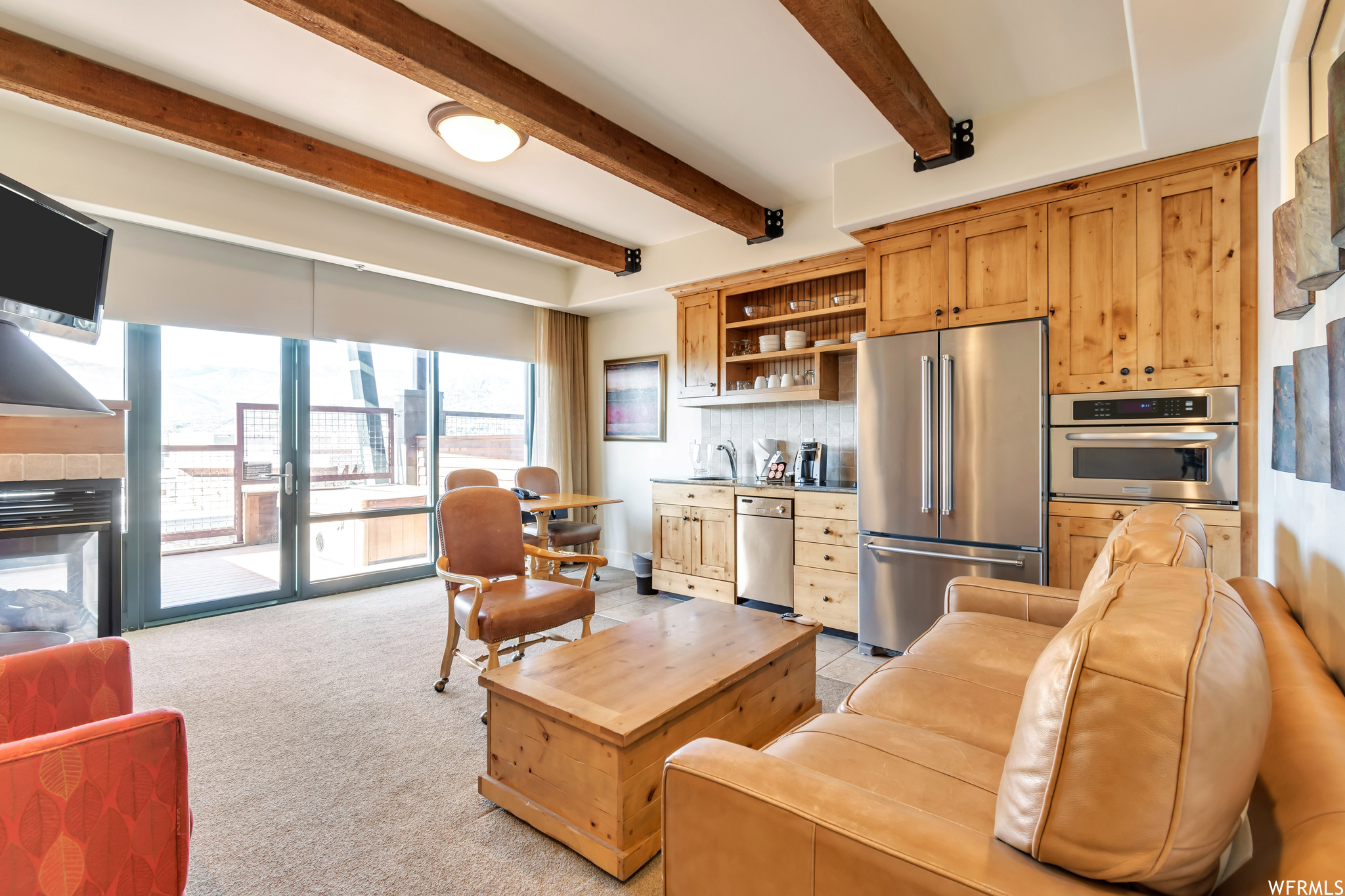 Carpeted living room featuring sink and beam ceiling