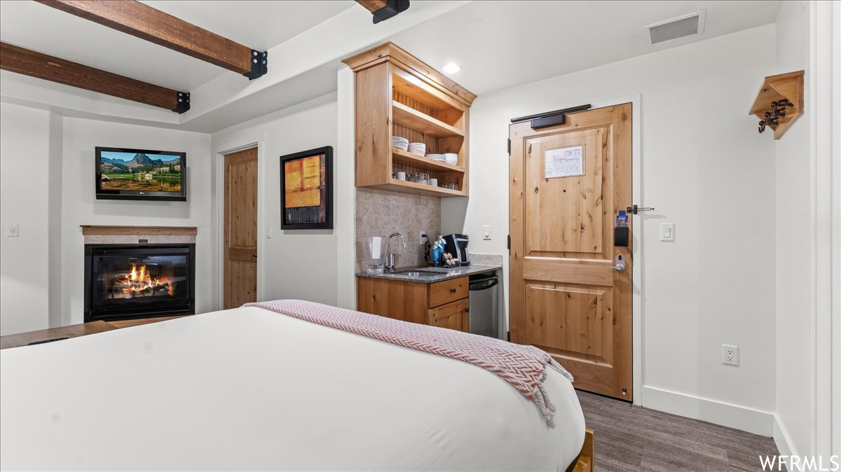 Bedroom featuring sink, dark hardwood flooring, and beamed ceiling