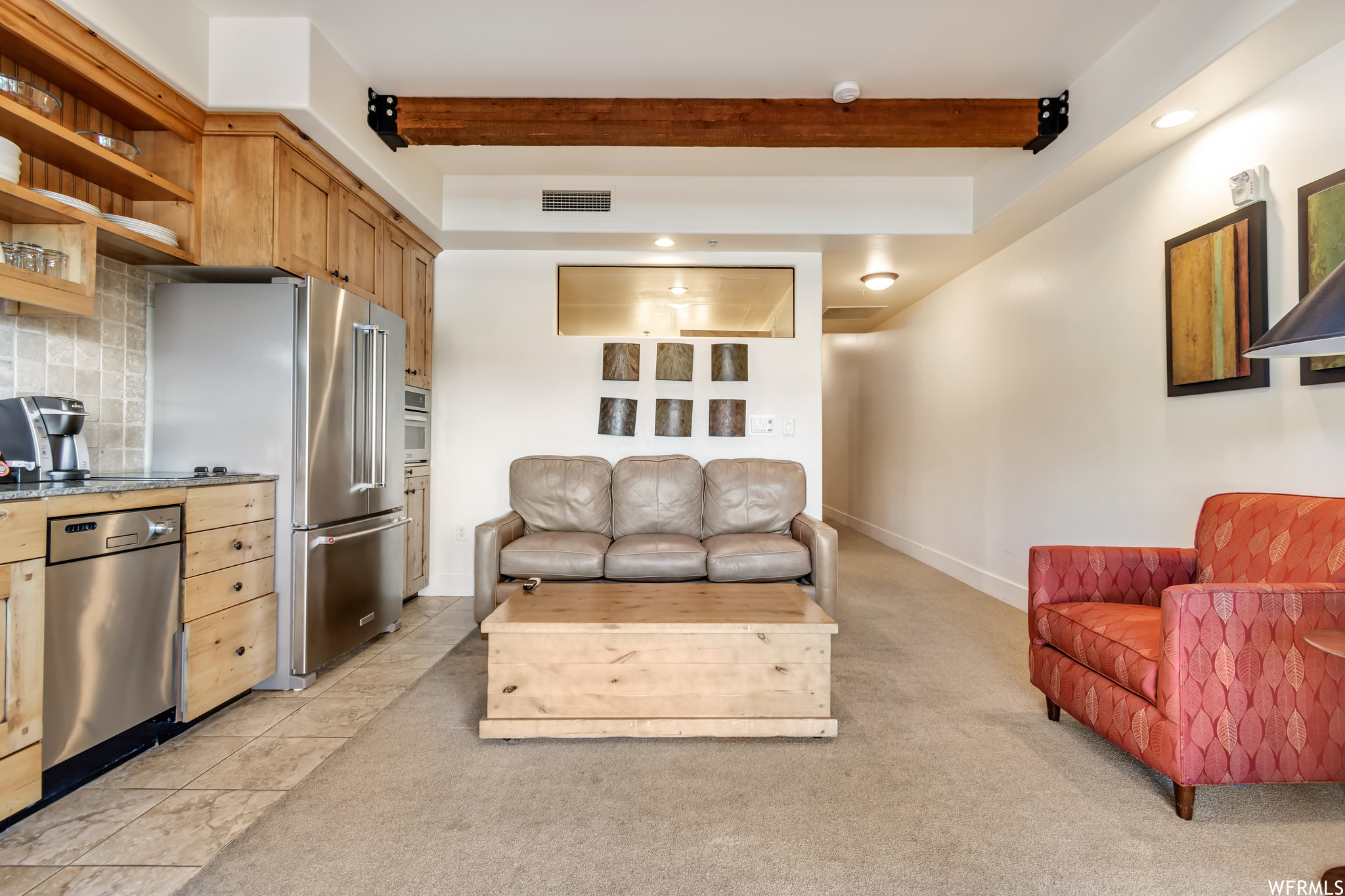 Living room featuring light carpet and beamed ceiling