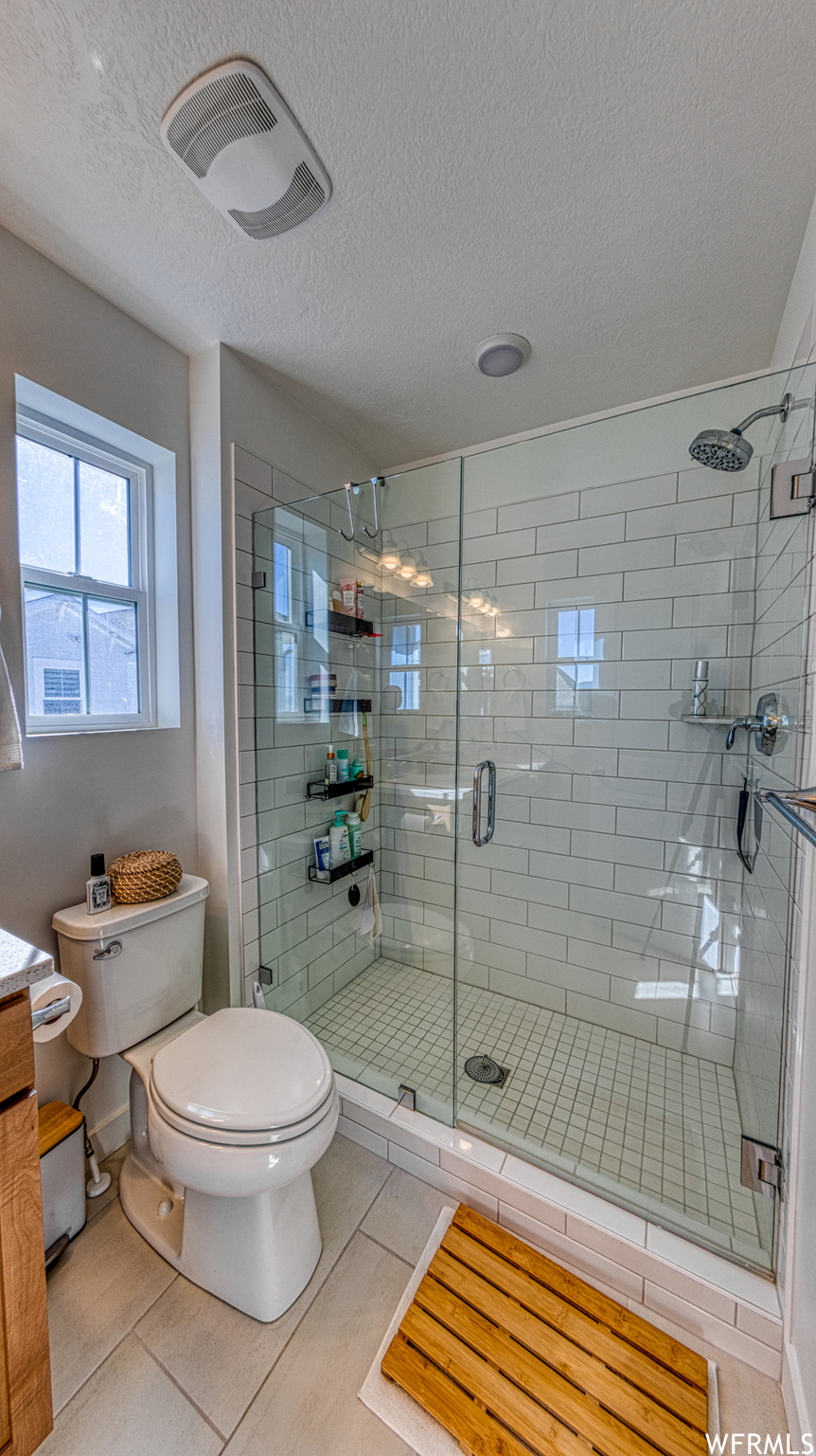 Master Bathroom with vanity, toilet, tile floors, and an enclosed shower
