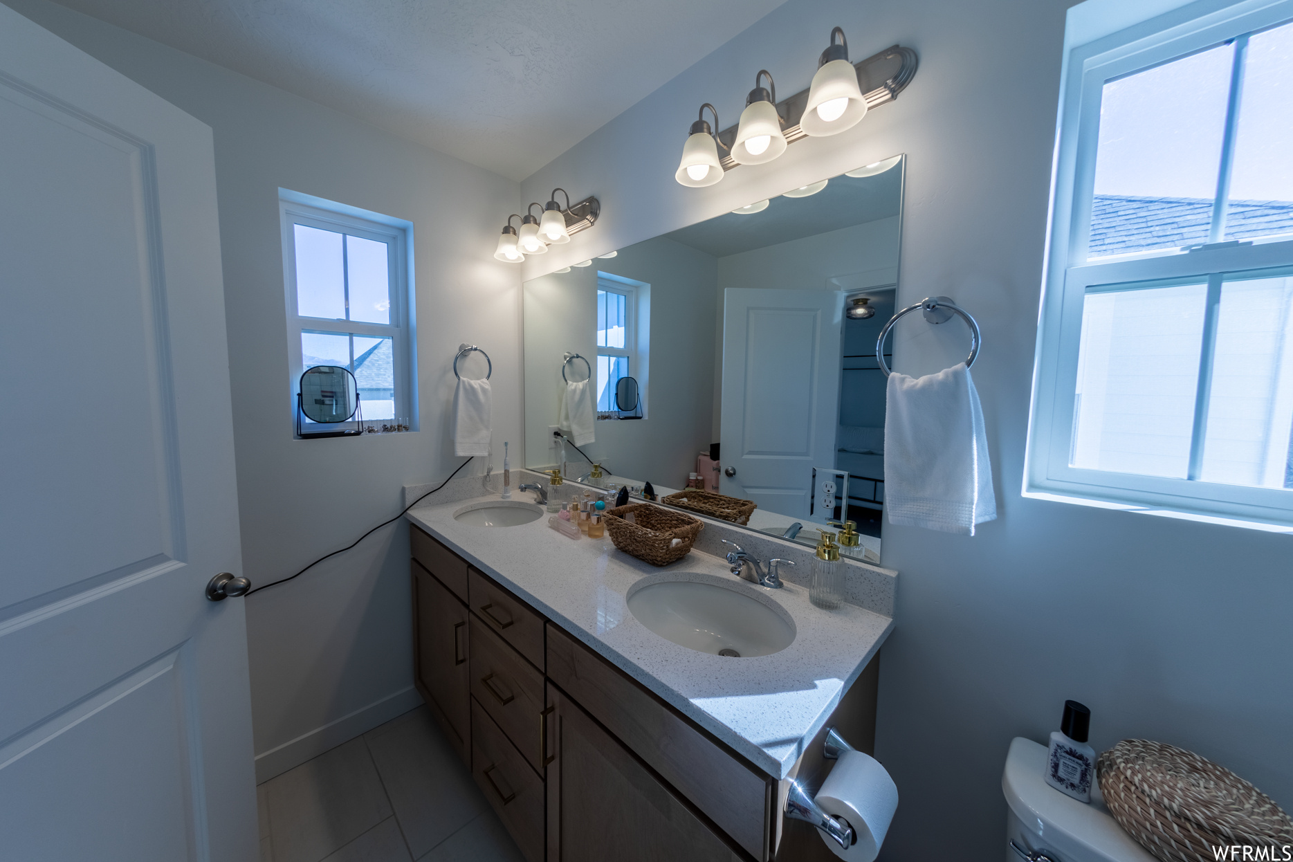 Master full Bathroom featuring tile floors, vanity with extensive cabinet space, and dual sinks