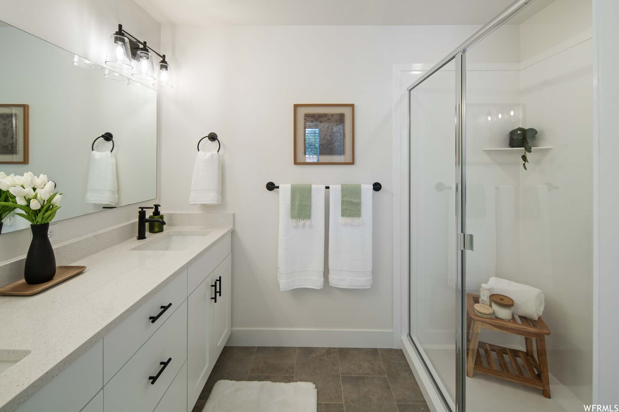 Bathroom with vanity, tile flooring, and an enclosed shower