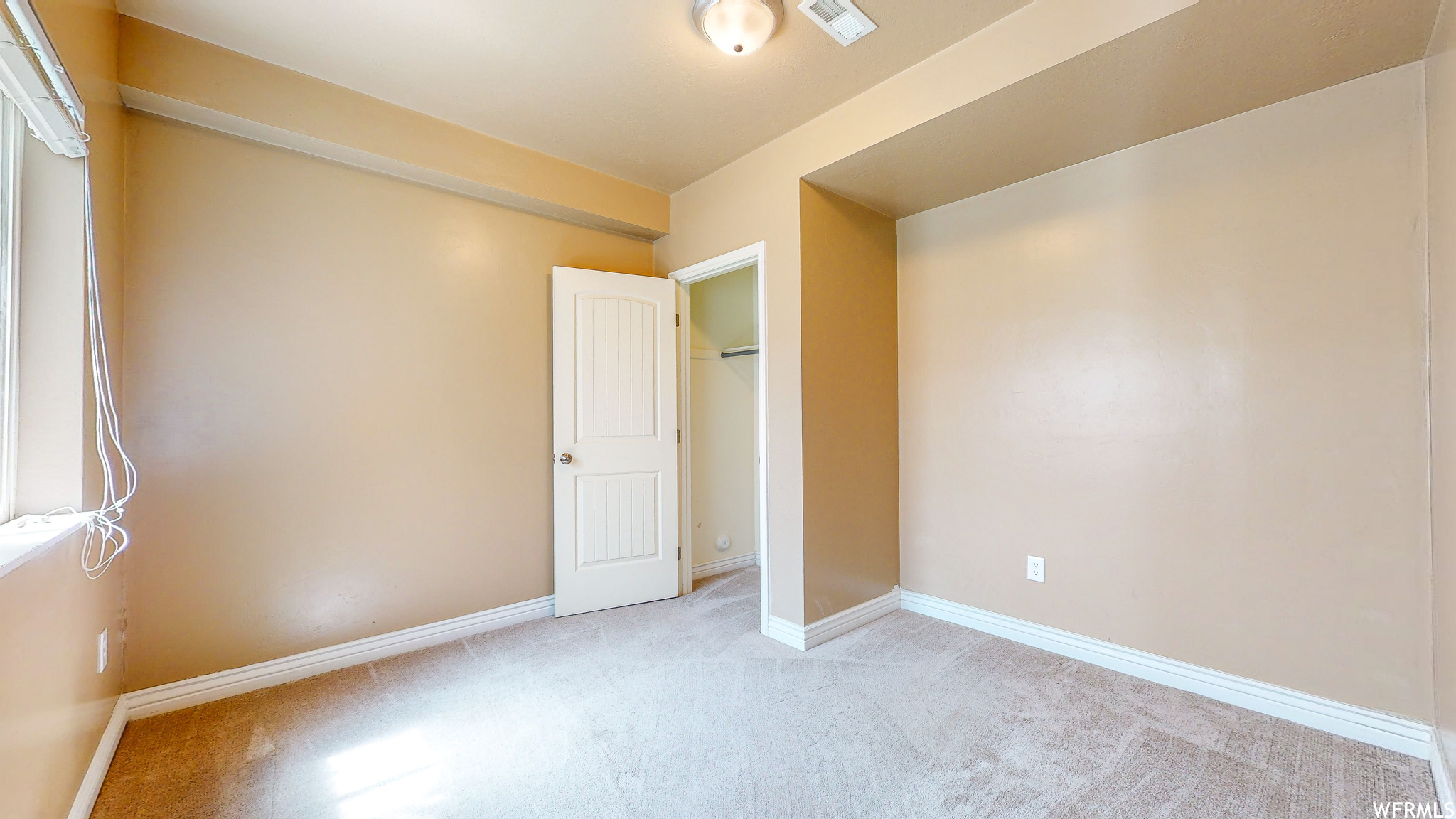 Basement bedroom with a closet and light colored carpet