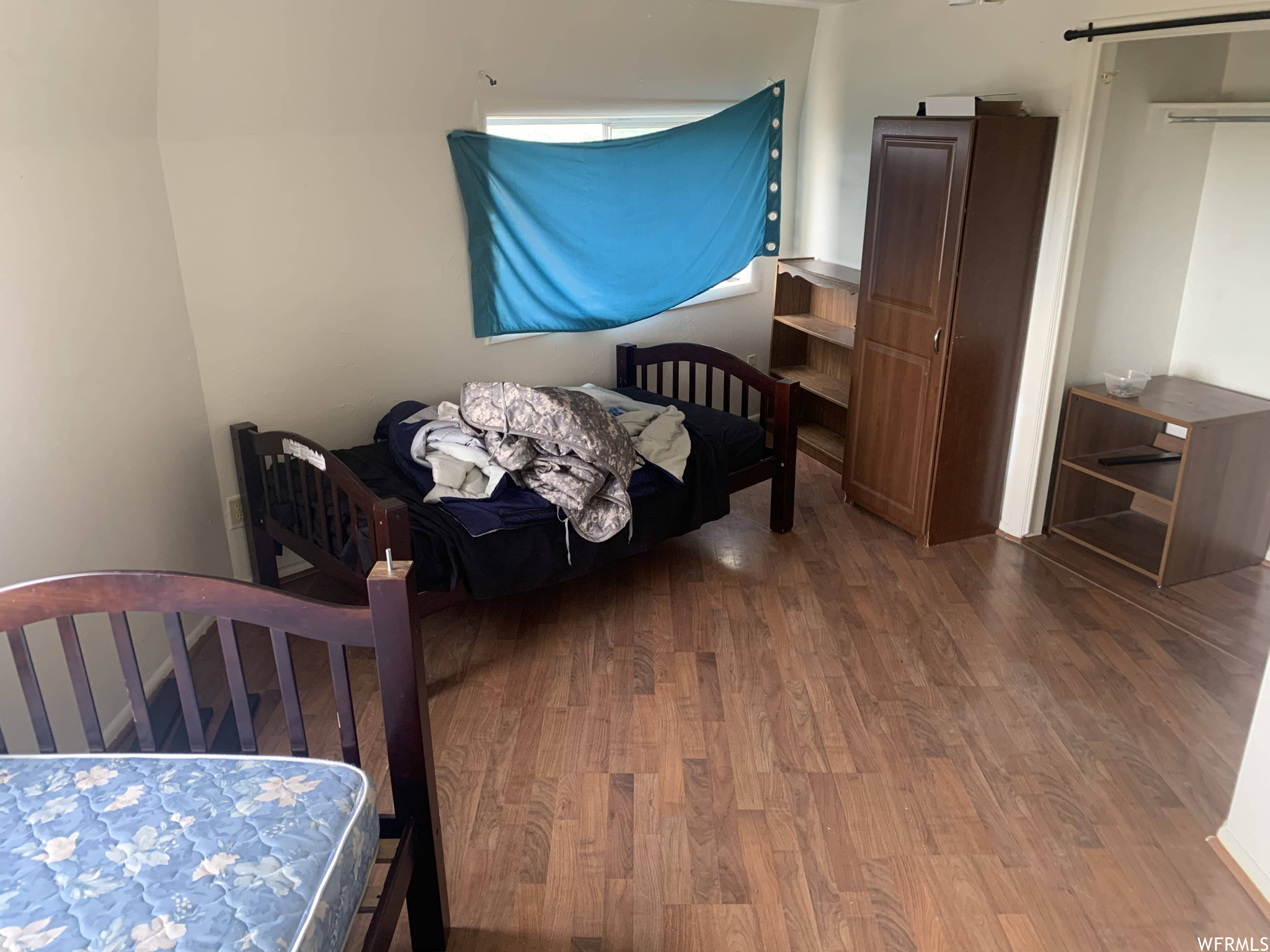 Bedroom featuring hardwood flooring and a closet