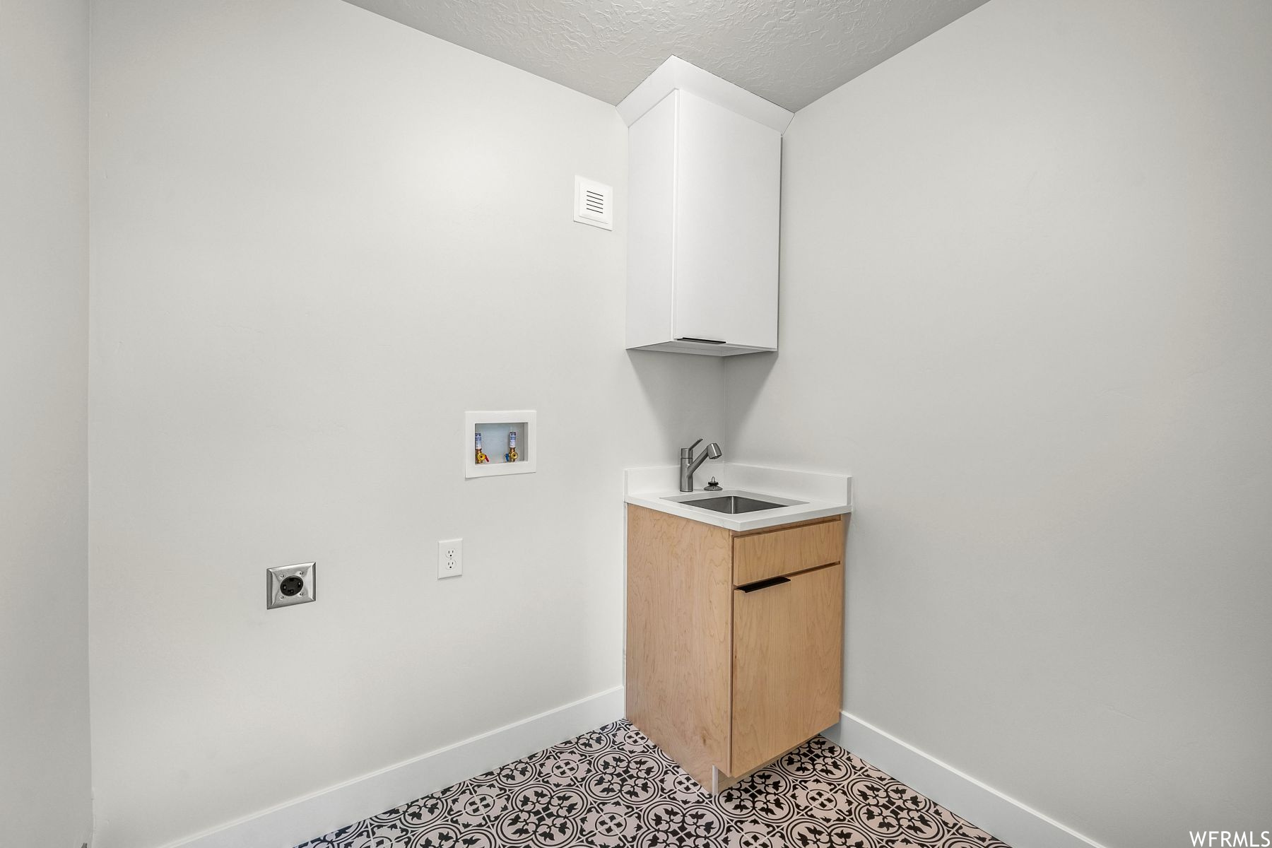 Laundry room with cabinets, light tile floors, hookup for an electric dryer, hookup for a washing machine, and sink