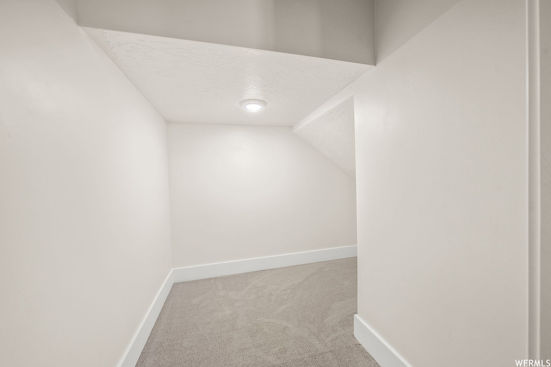Carpeted spare room with lofted ceiling and a textured ceiling