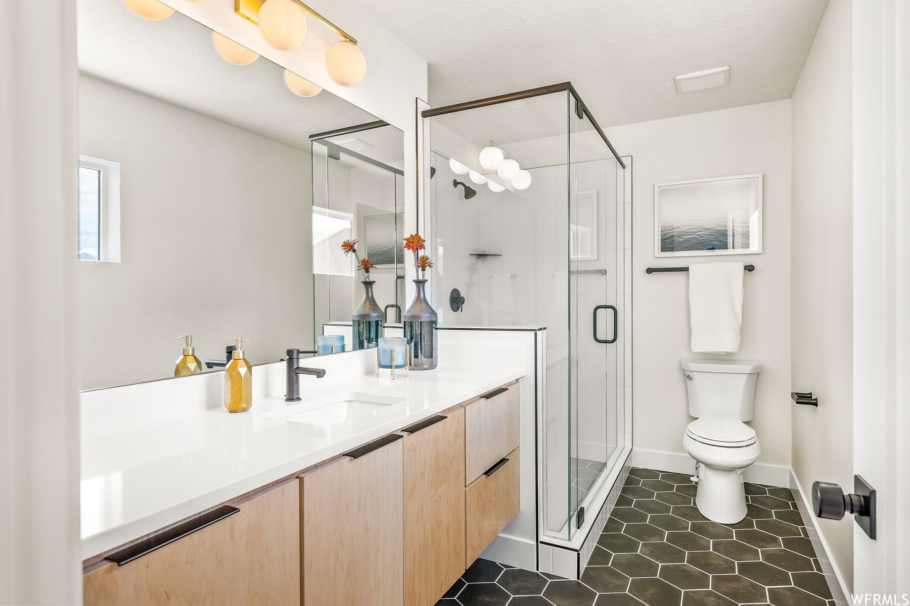 Bathroom featuring toilet, a shower with shower door, vanity, and tile flooring