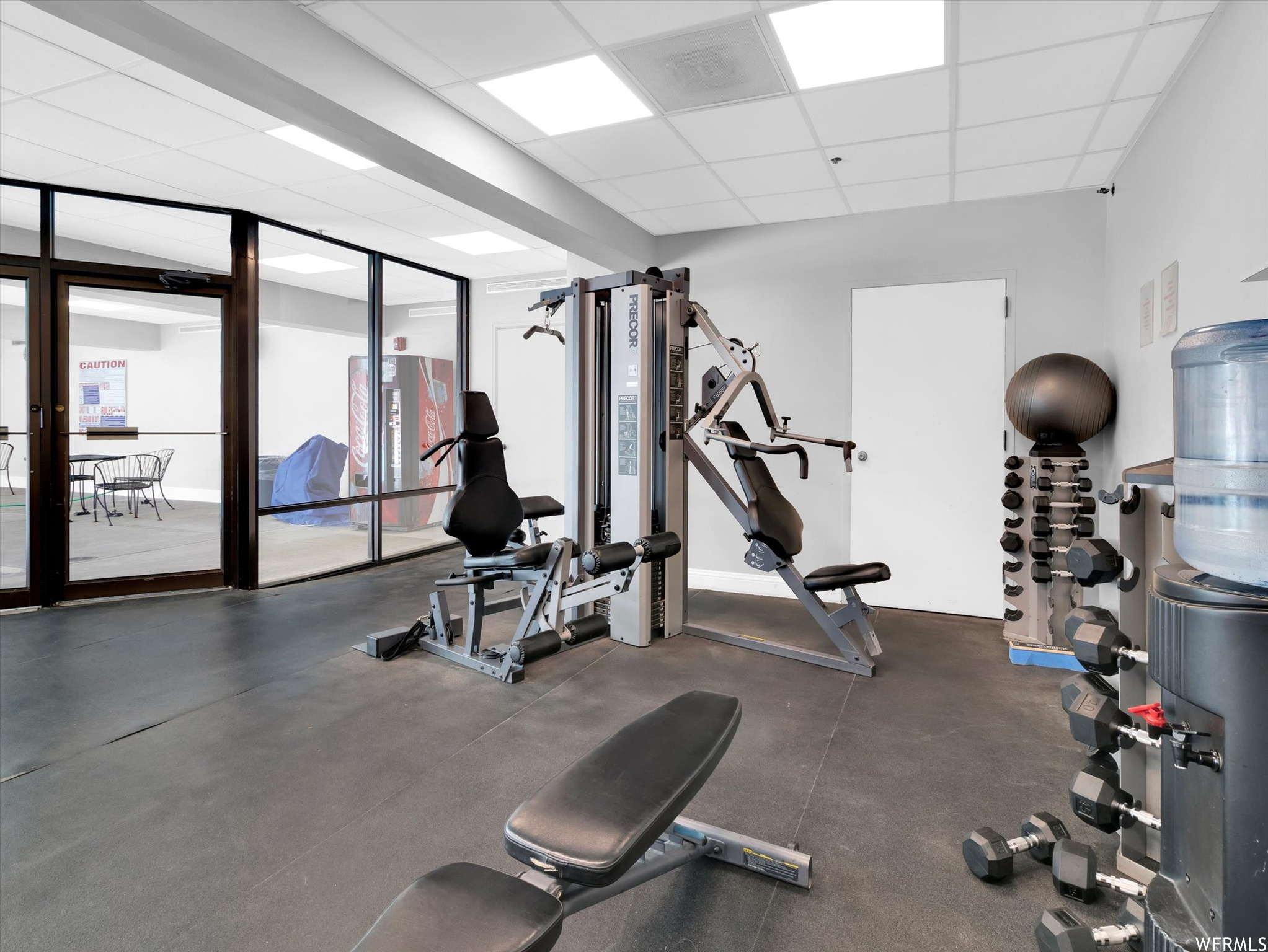 Exercise room with expansive windows and a paneled ceiling
