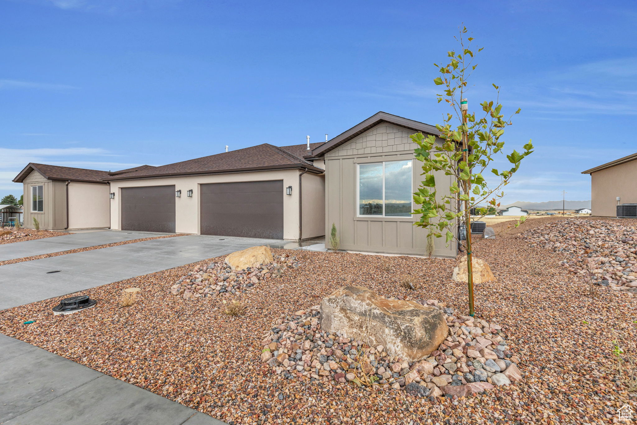 Ranch-style home featuring a garage and central air condition unit