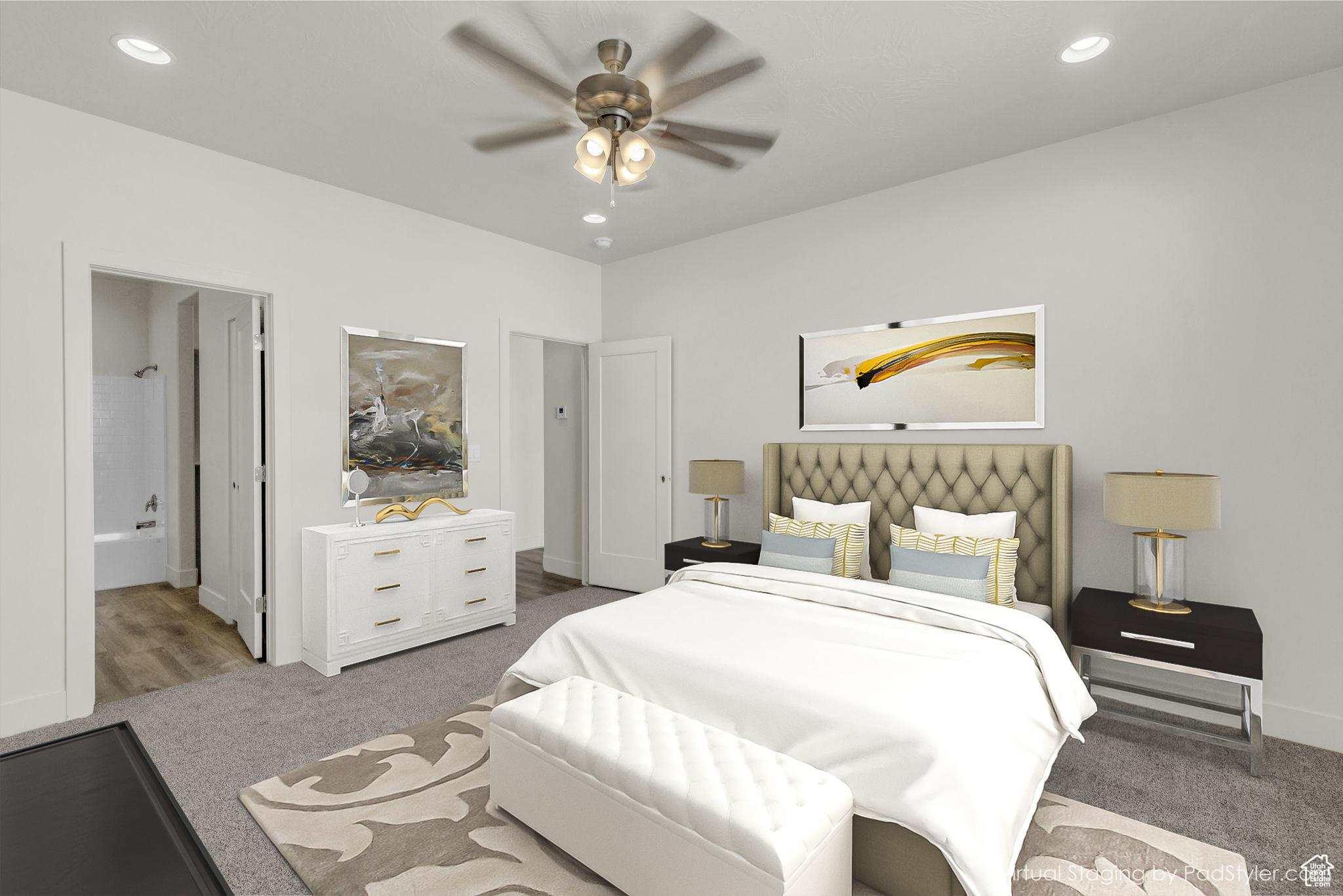 Carpeted bedroom featuring ensuite bath and ceiling fan