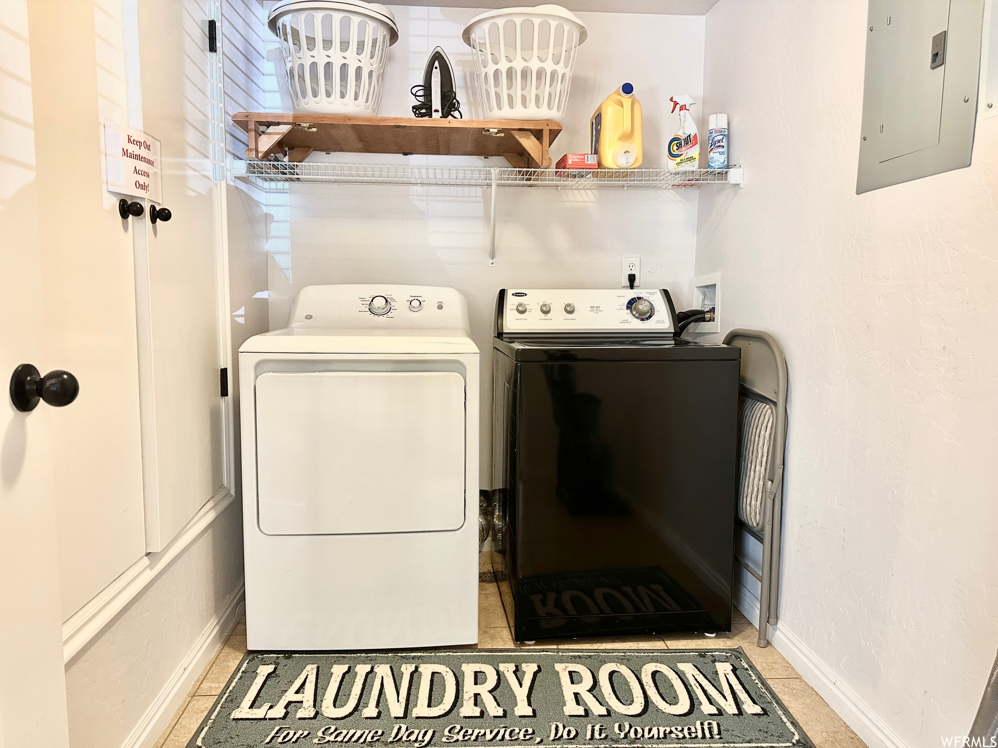 Clothes washing area featuring washer and clothes dryer, light tile flooring, and hookup for a washing machine